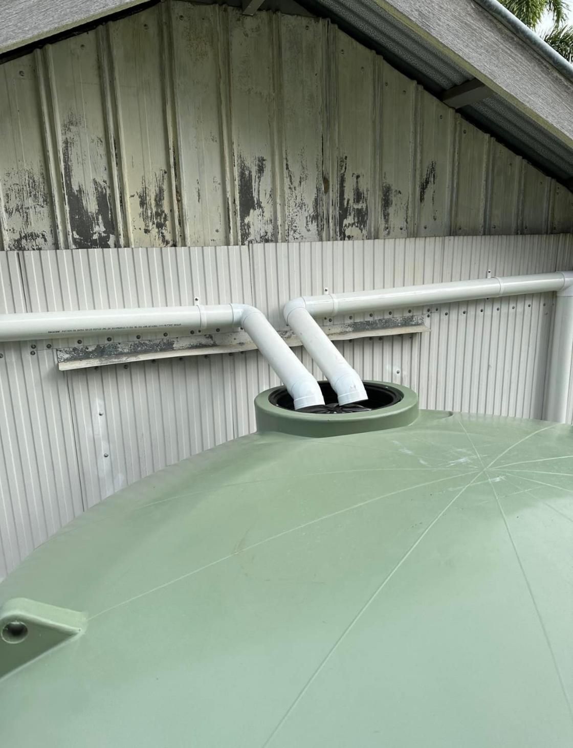A Green Water Tank with White Pipes Attached to It — Top To Bottom Plumbing in Garbutt, QLD