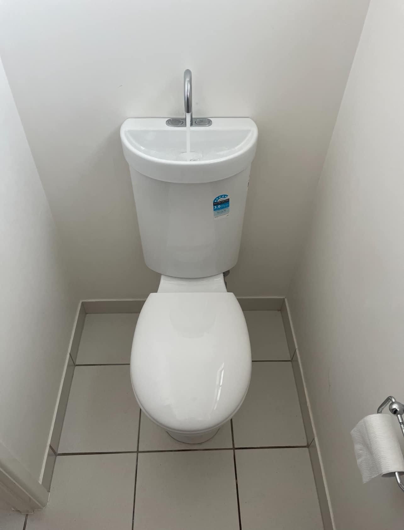 A Toilet Is Sitting in A Small Bathroom Next to A Sink — Top To Bottom Plumbing in Garbutt, QLD