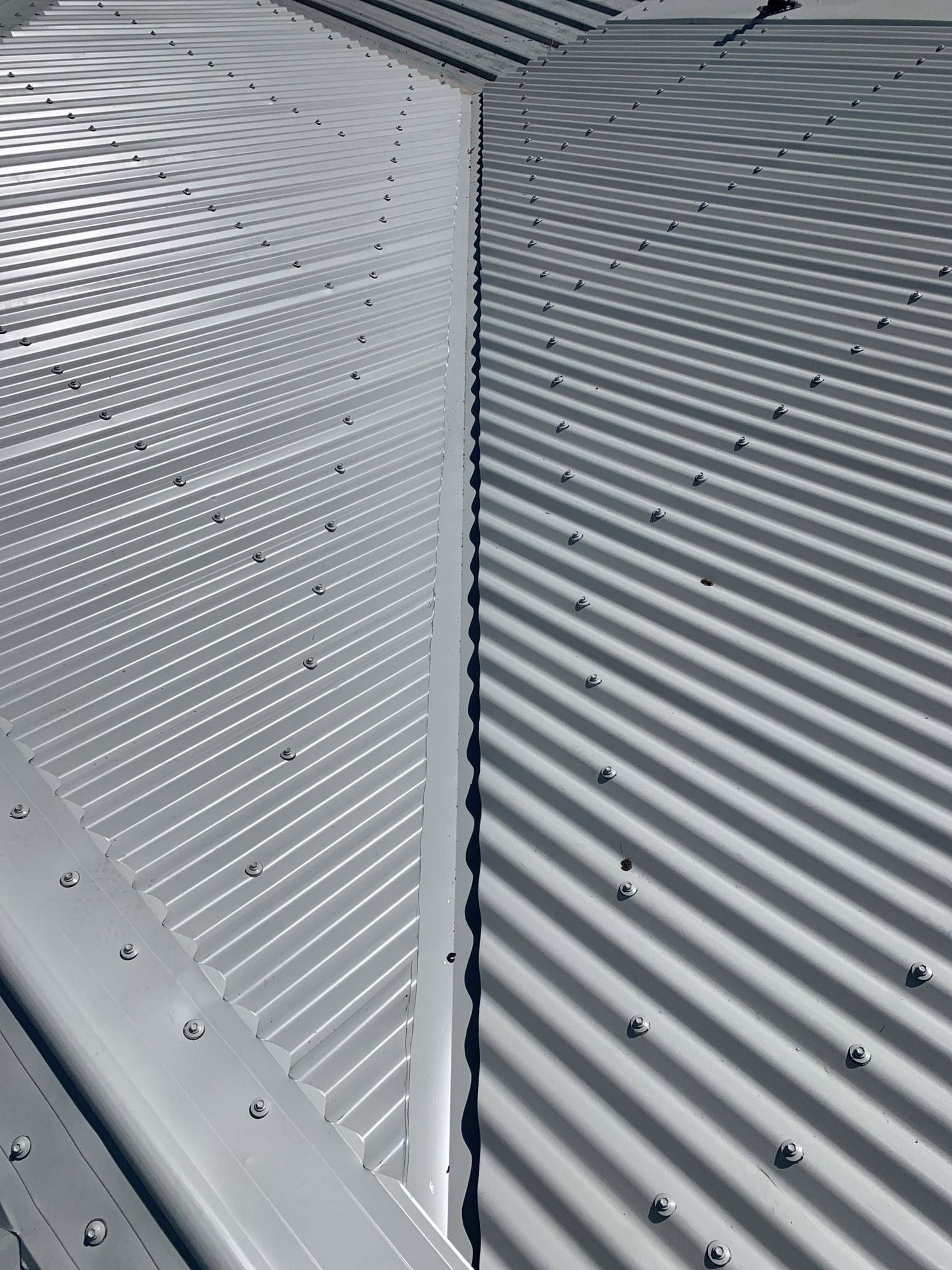 Gray Metal Roof With Corrugated and Perforated Sections — Top To Bottom Plumbing in Garbutt, QLD