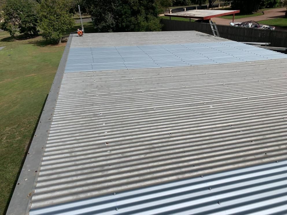 The Roof of A Building with A Boat in The Background — Top To Bottom Plumbing in Garbutt, QLD