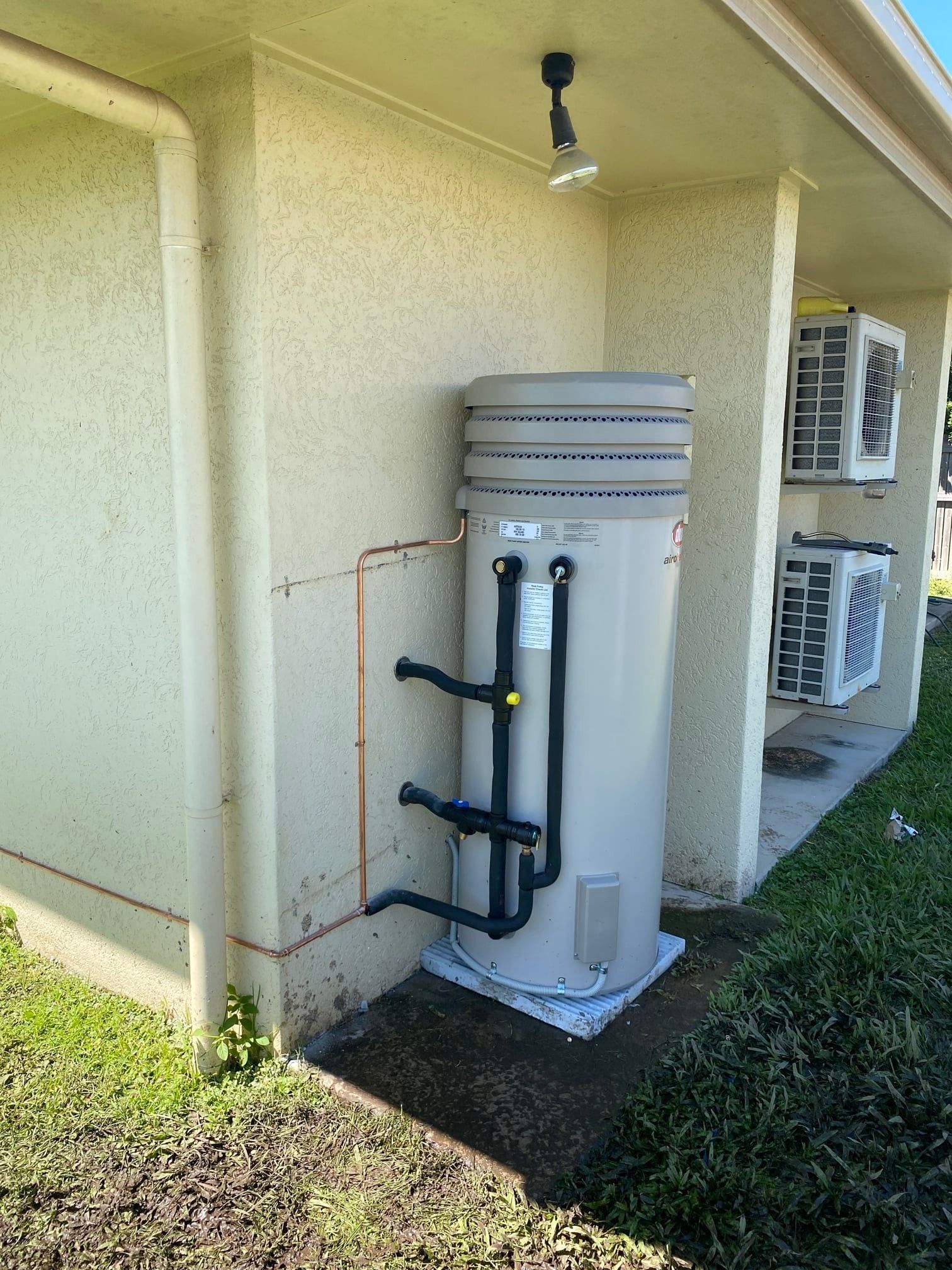 Water Heater Installed on a Concrete Slab Against a Building Wall — Top To Bottom Plumbing in Garbutt, QLD