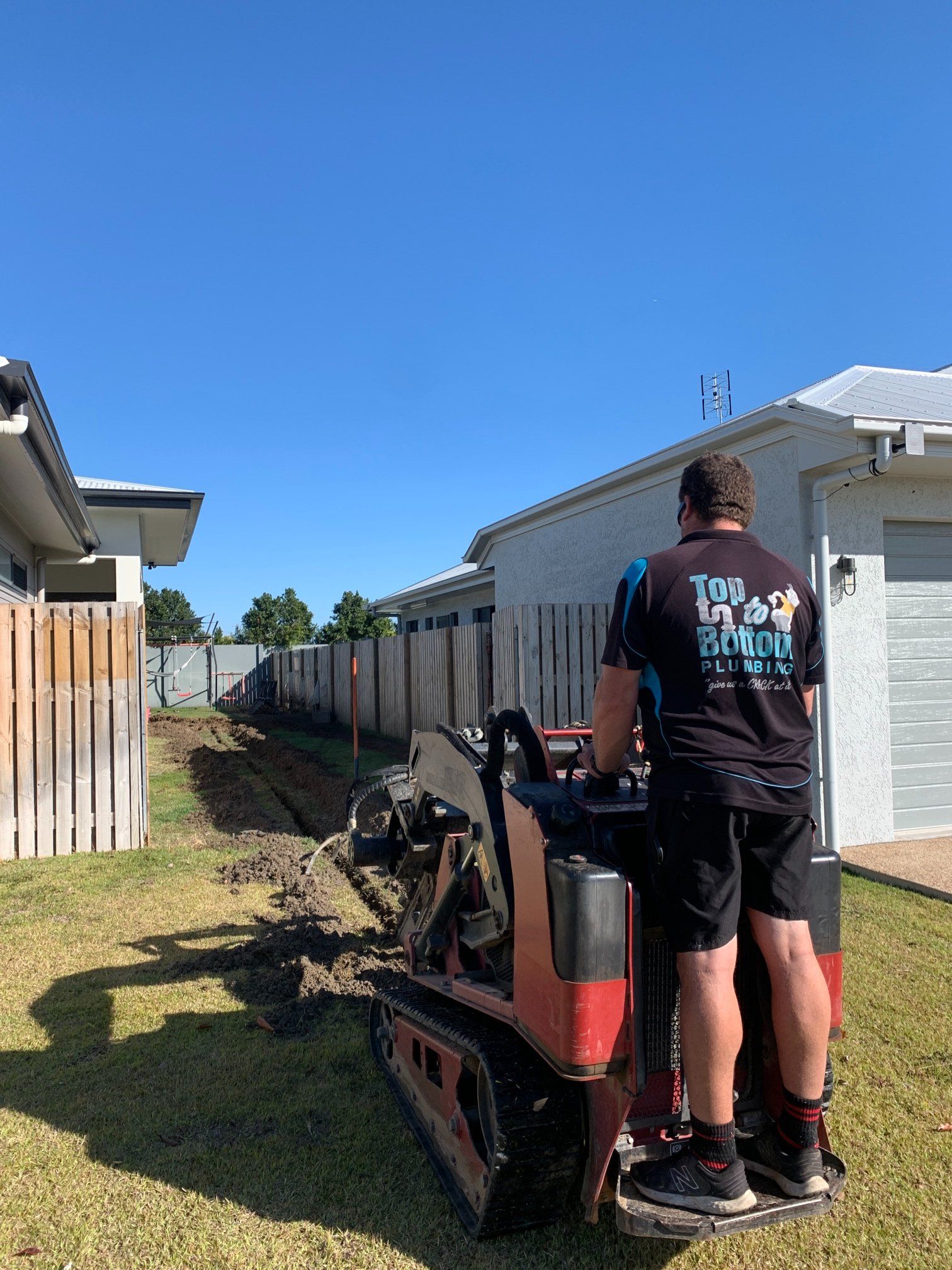 Man Operating a Mini Trencher in a Yard — Top To Bottom Plumbing in Garbutt, QLD