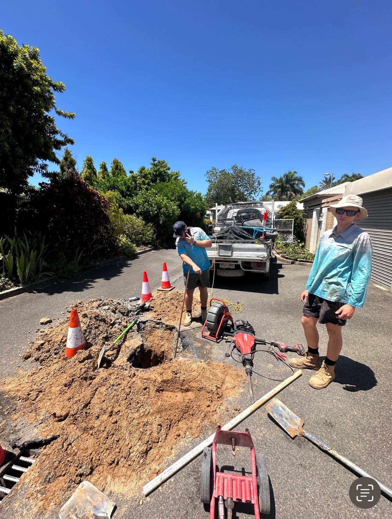 Two People Working on a Dug-up Area in a Driveway — Top To Bottom Plumbing in Garbutt, QLD