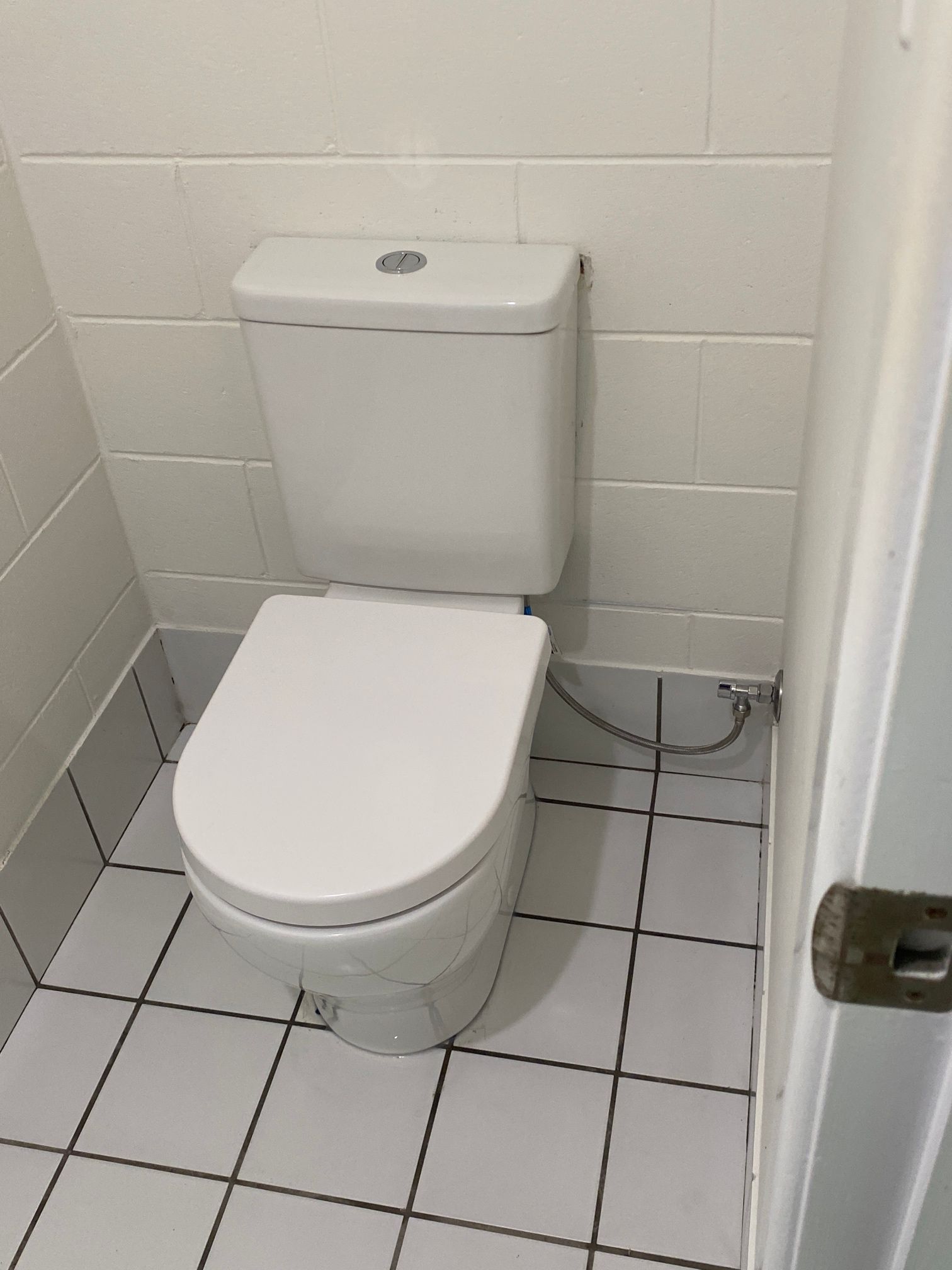 A Person Is Applying Silicone to A Toilet — Top To Bottom Plumbing in Garbutt, QLD