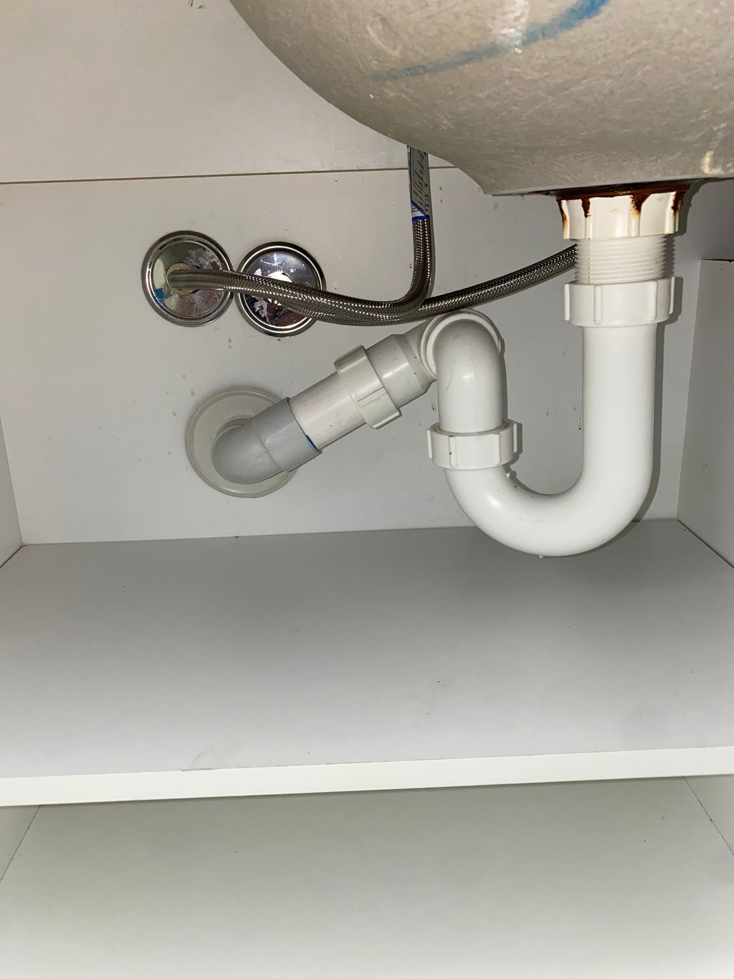 A Man Is Using a Machine to Drain a Drain Outside of A House — Top To Bottom Plumbing in Garbutt, QLD