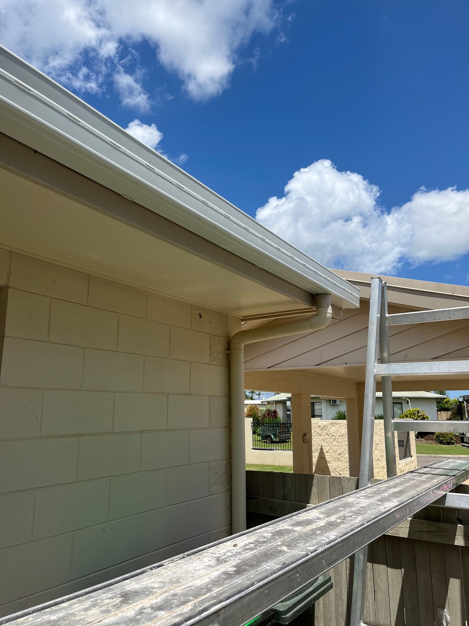 A Close up Of a White Corrugated Metal Roof with A Gutter — Top To Bottom Plumbing in Garbutt, QLD