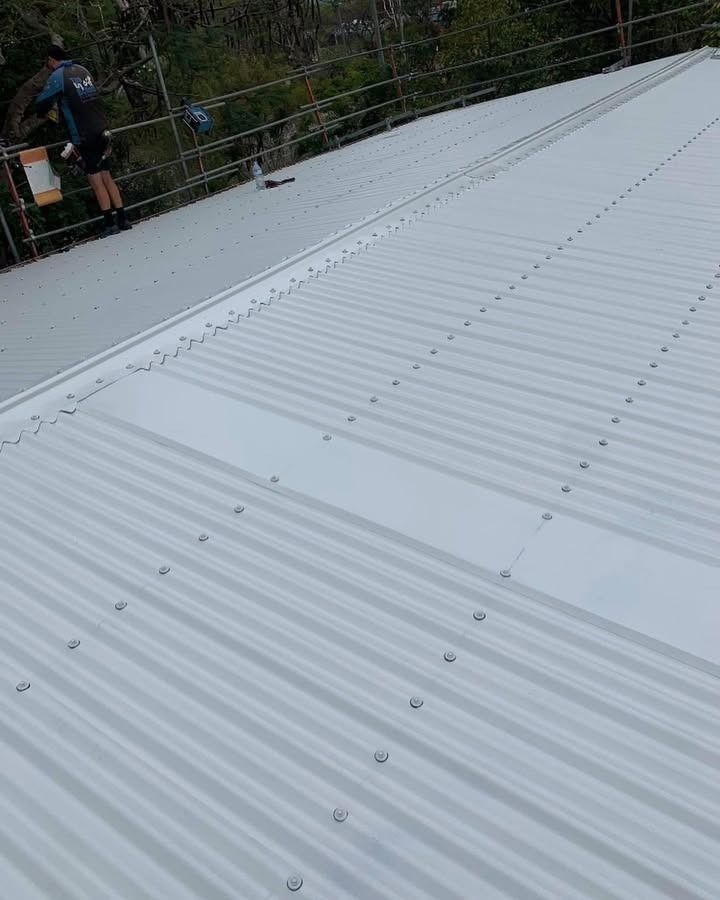 Roofer Working on a Large Corrugated Metal Roof