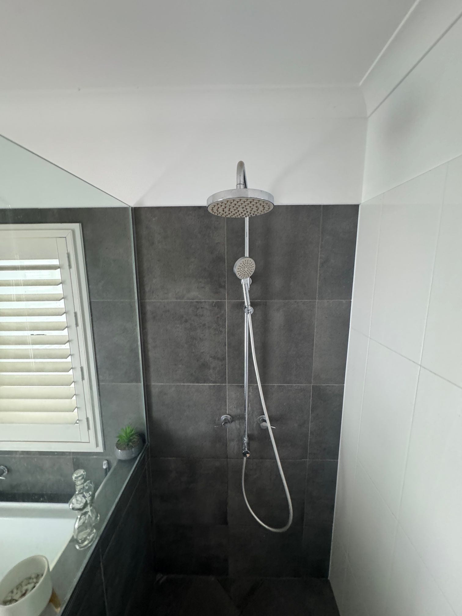 A Shower Head Is Attached to A Wall in A Bathroom — Top To Bottom Plumbing in Garbutt, QLD
