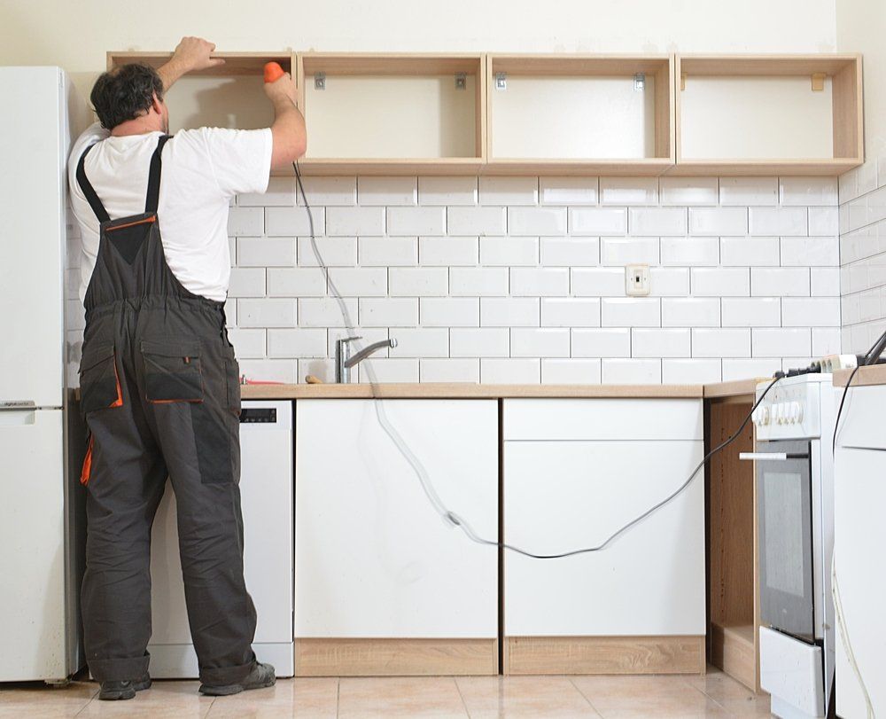Man Installing New Kitchen Cabinetry — Renovation Services in Tamworth, NSW