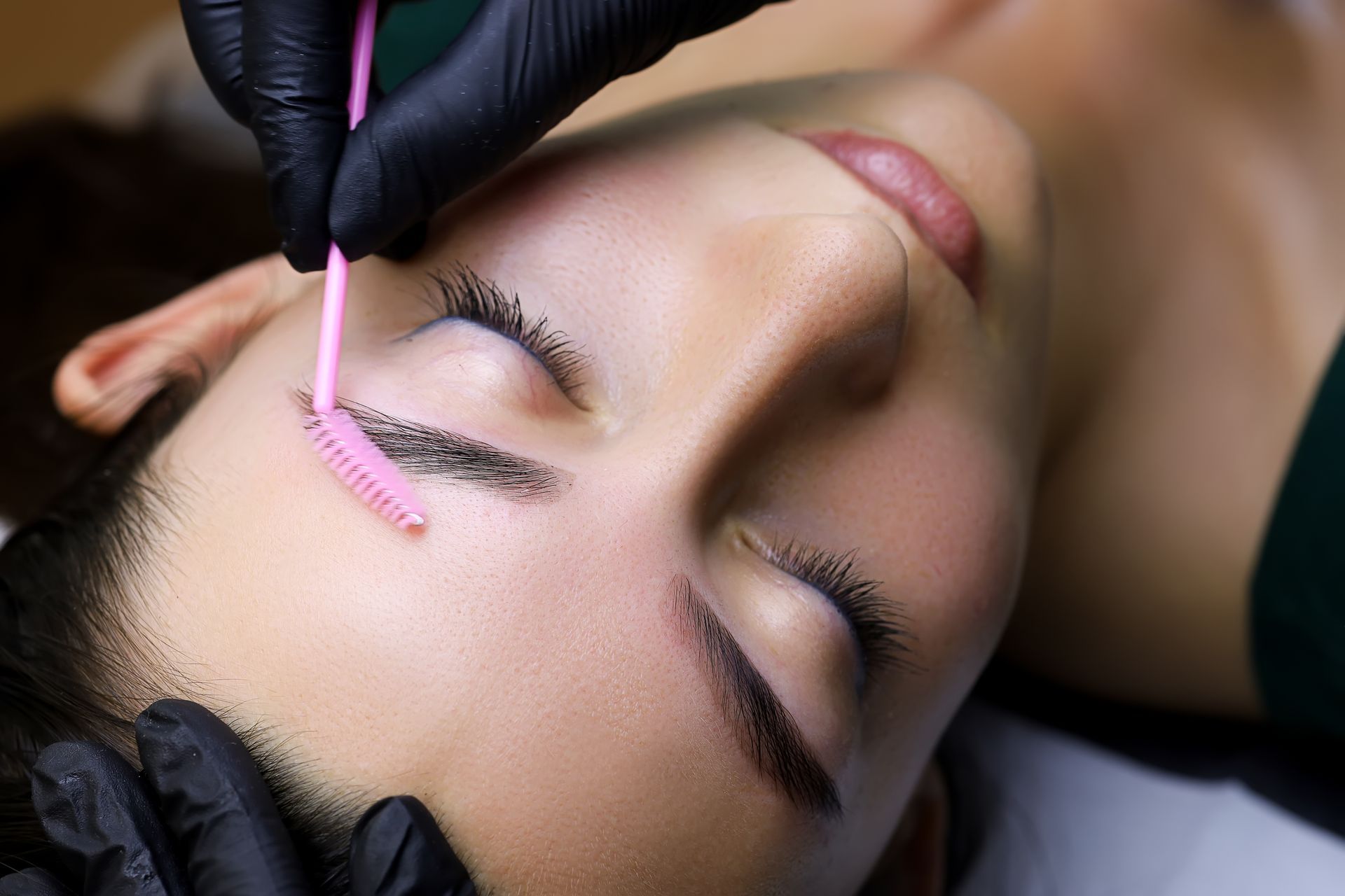 A woman is getting her eyelashes done at a beauty salon.
