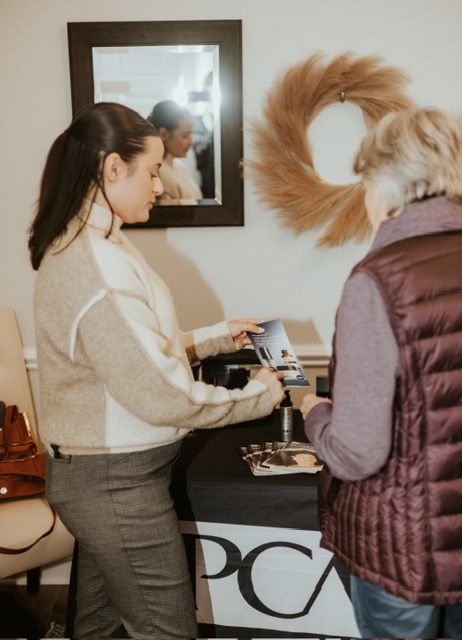 Two people stand at a table branded with 