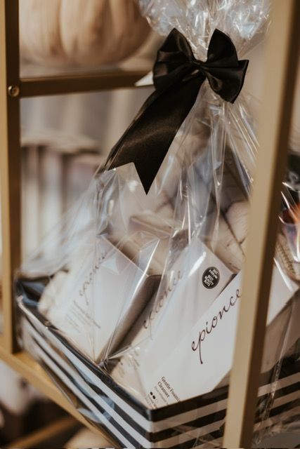 A gift basket with black and white stripes, containing Epionce skincare products, wrapped in plastic with a black bow.