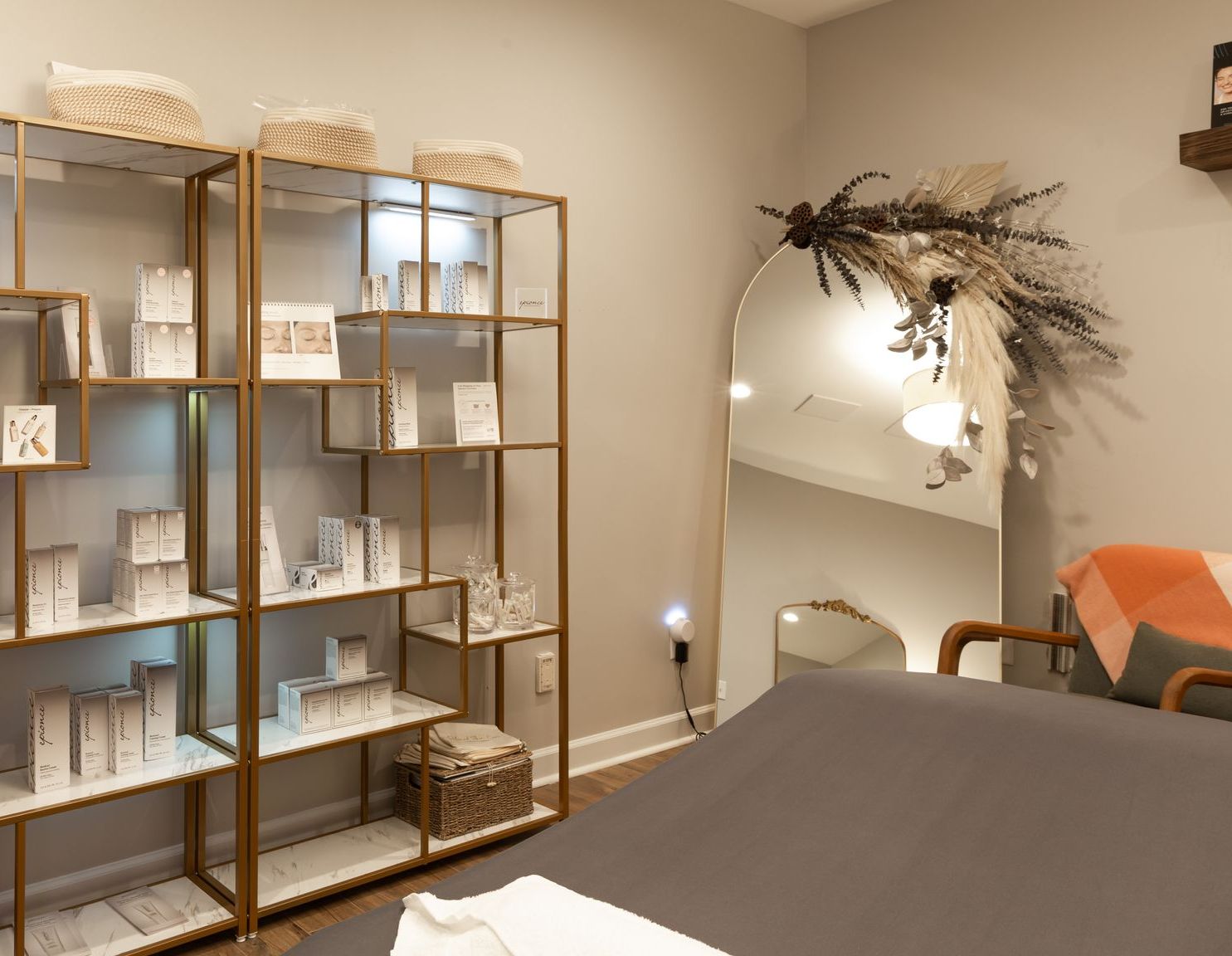 A room with a bed, shelves, and a mirror.