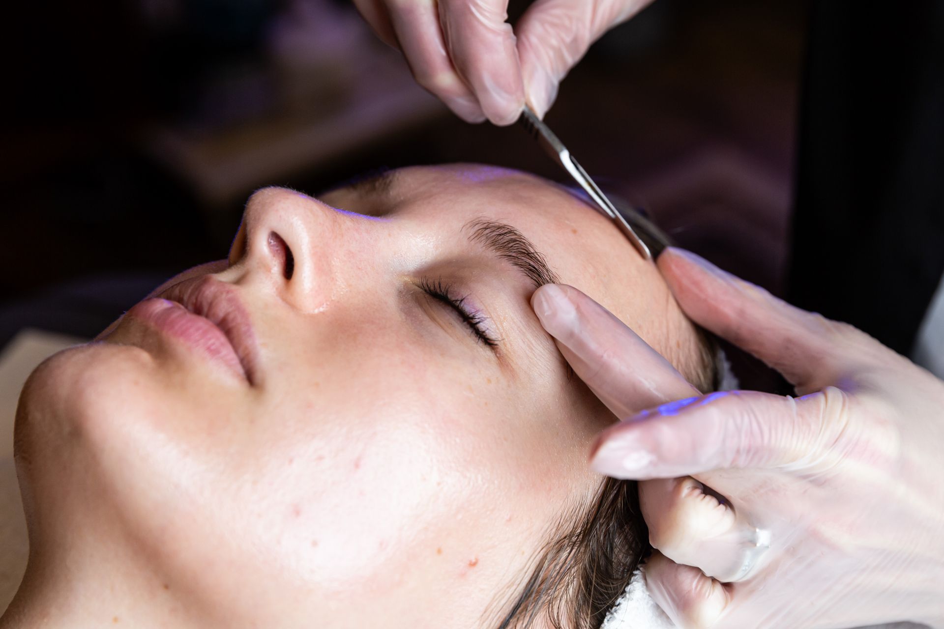 A woman is getting her eyebrows waxed at a beauty salon.