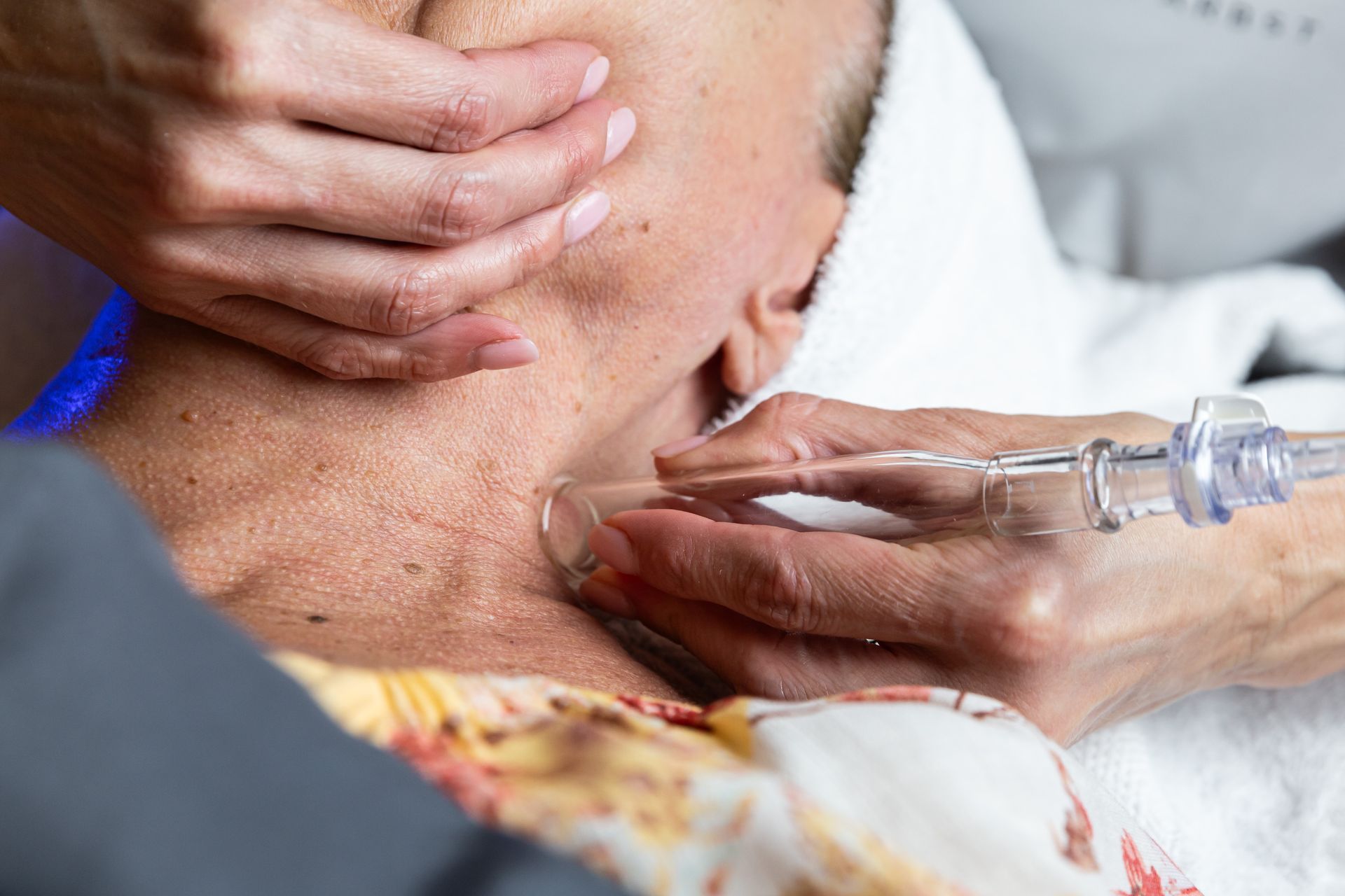 A woman is getting a facial treatment in her neck.