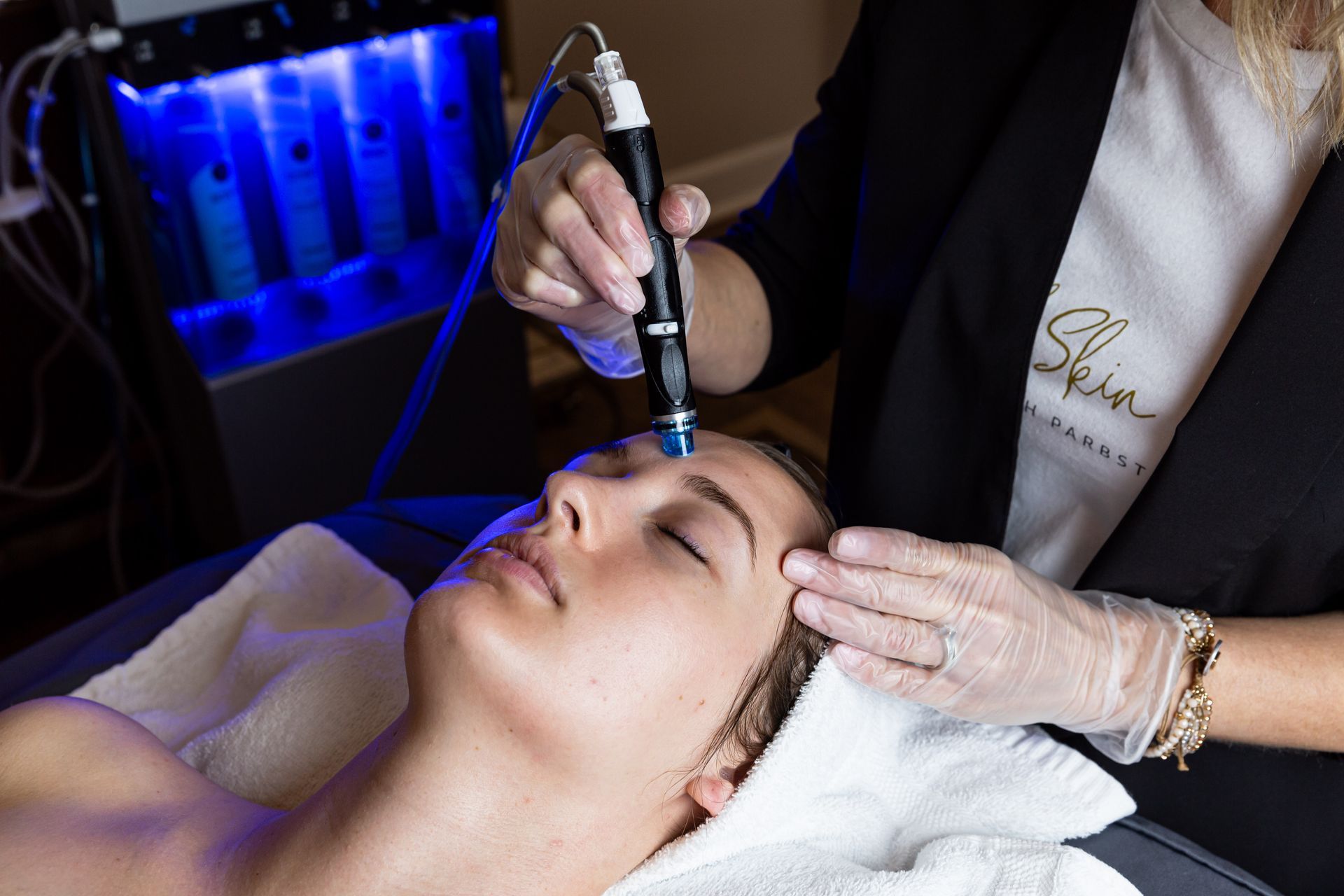A woman is getting a facial treatment at a beauty salon.