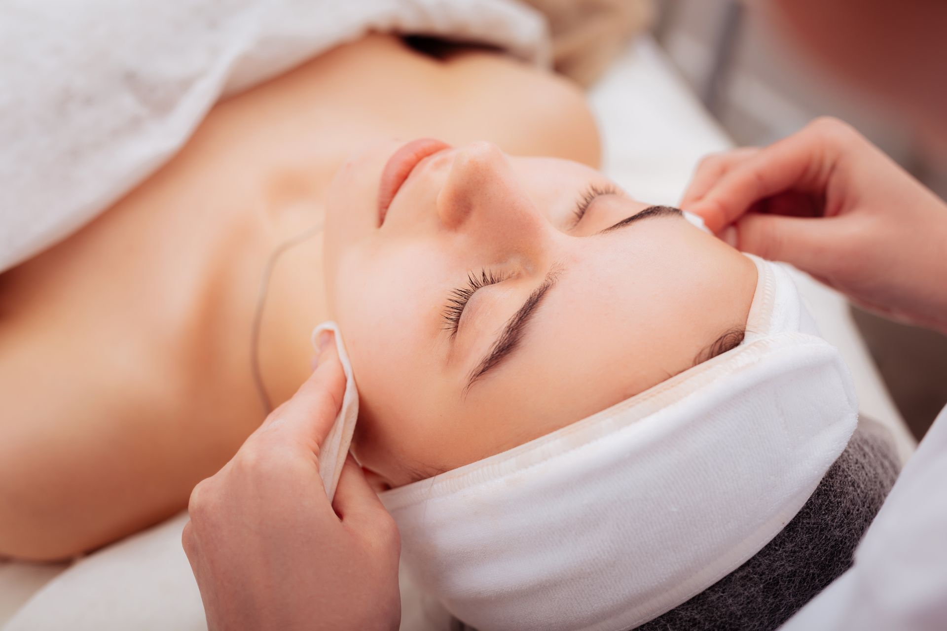 A woman is getting a treatment on her face