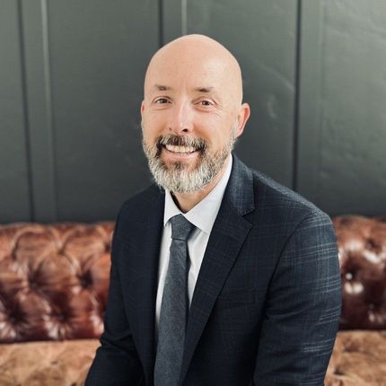 A man in a suit and tie is sitting on a couch.