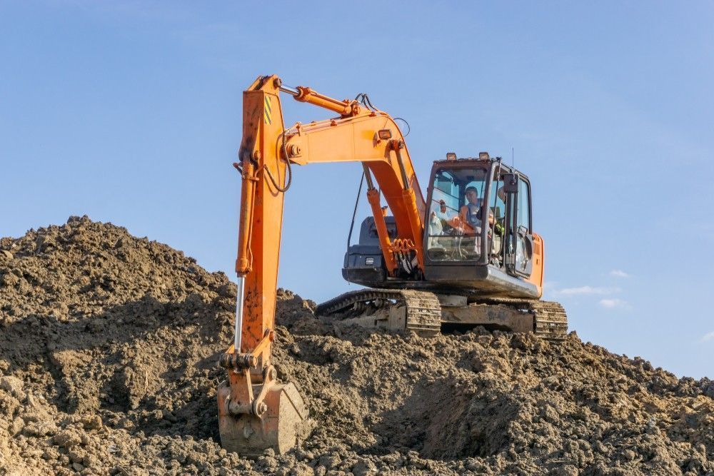 An Orange Excavator Digging in A Pile of Dirt — Barry Brown Rural Contracting Service in Wingham, NSW