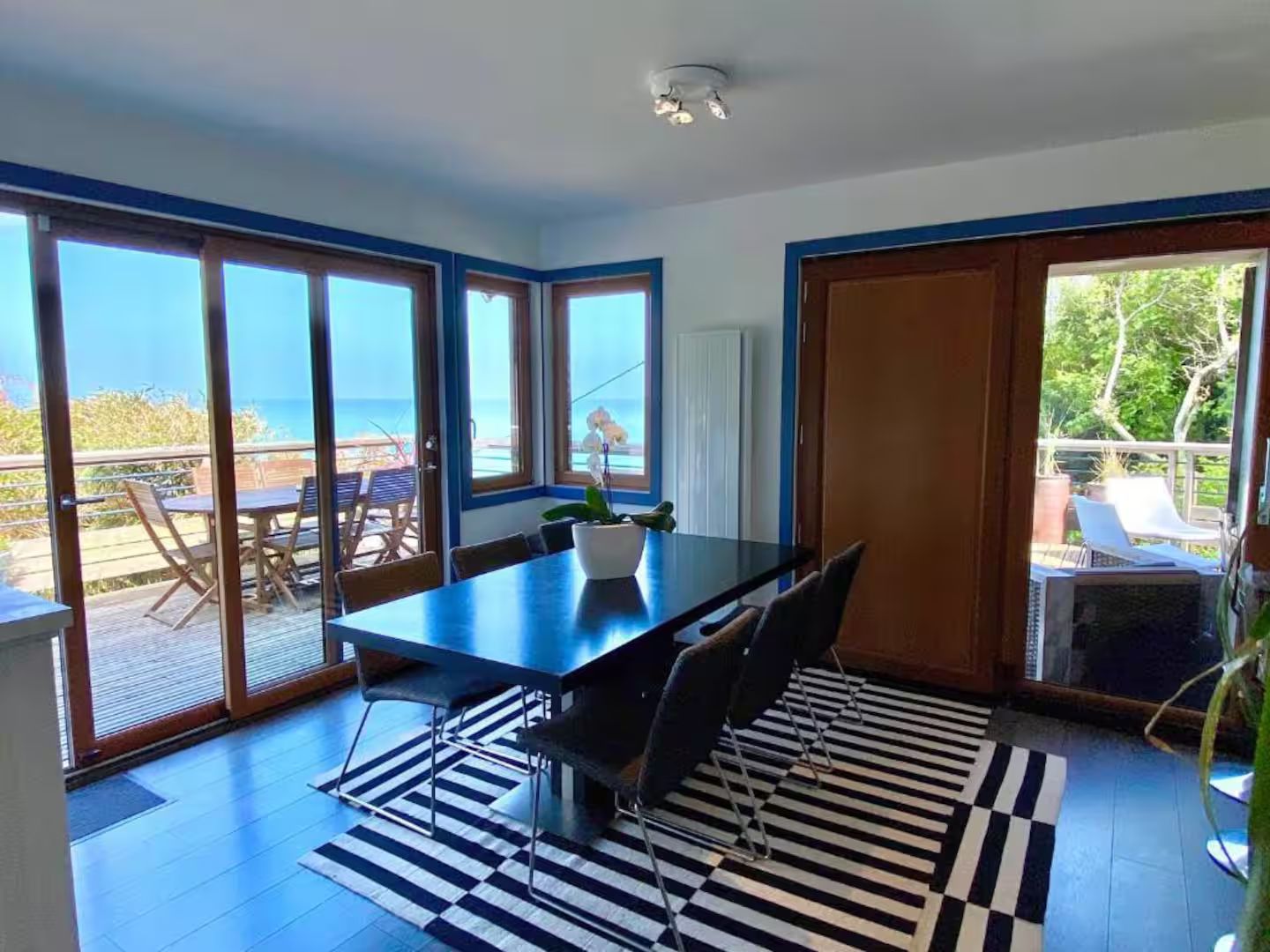 Une salle à manger avec une table et des chaises et un tapis rayé.