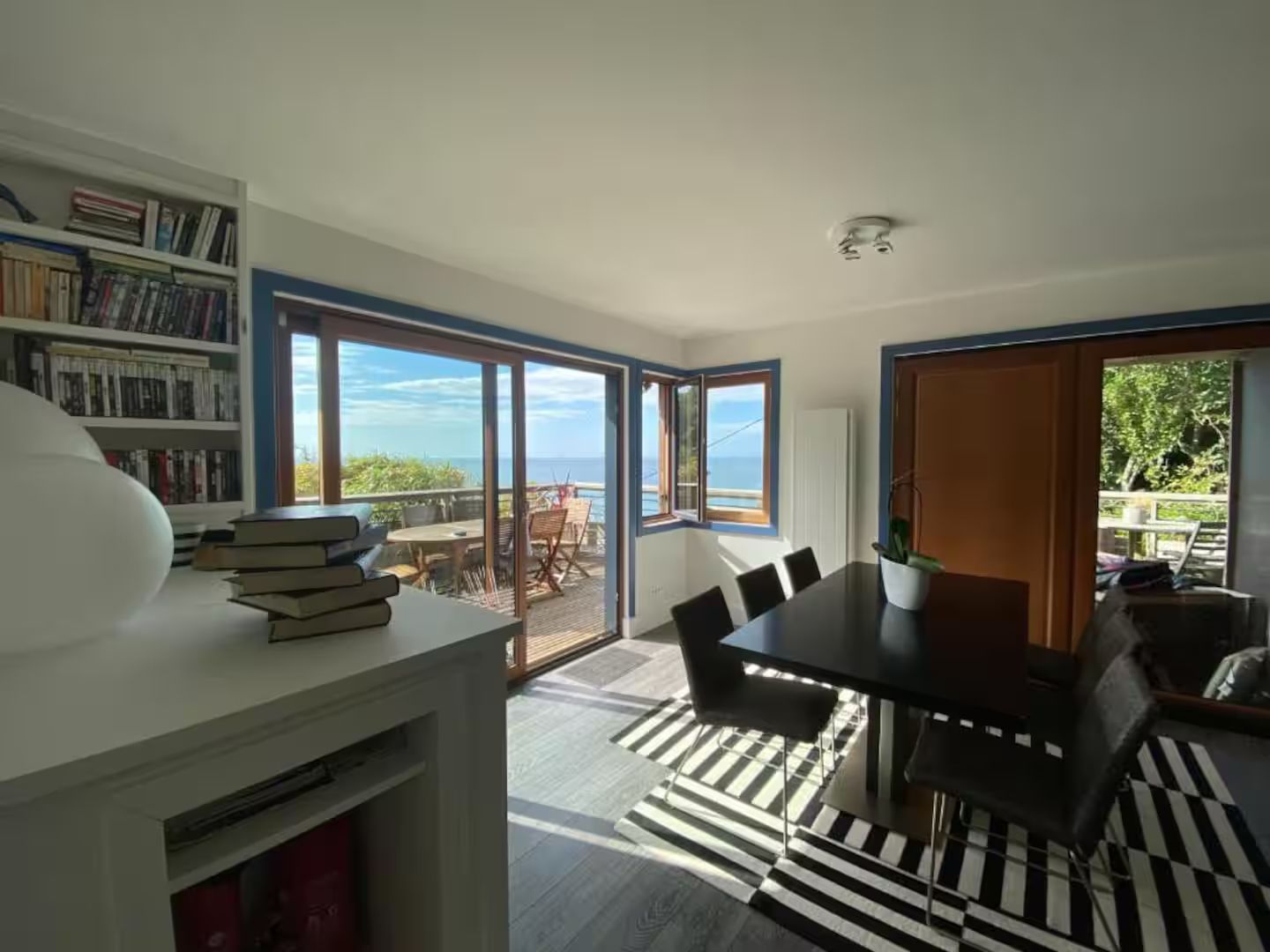 Une salle à manger avec une table et des chaises et un tapis noir et blanc.