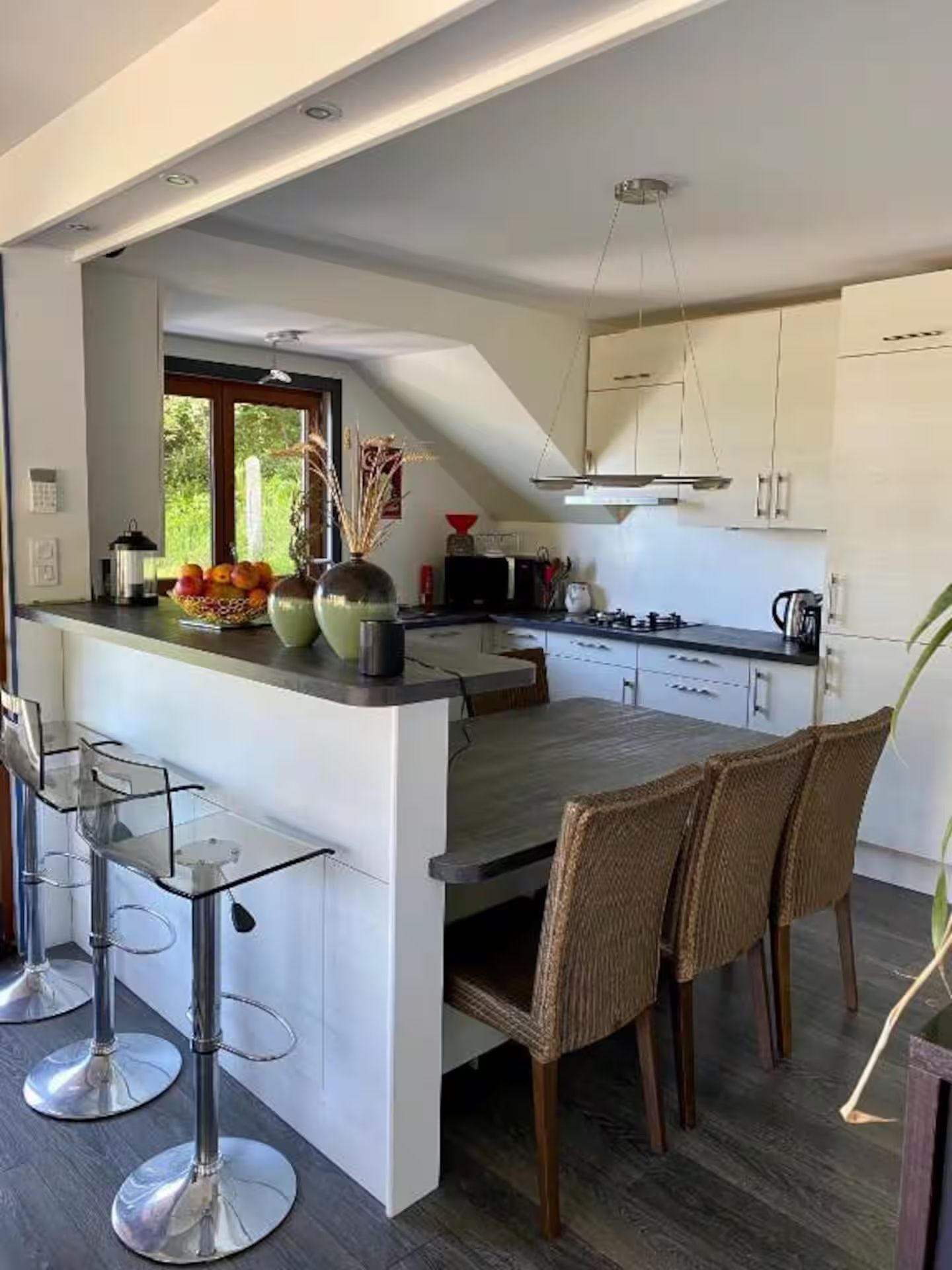 Une cuisine avec une table et des chaises et un bar.