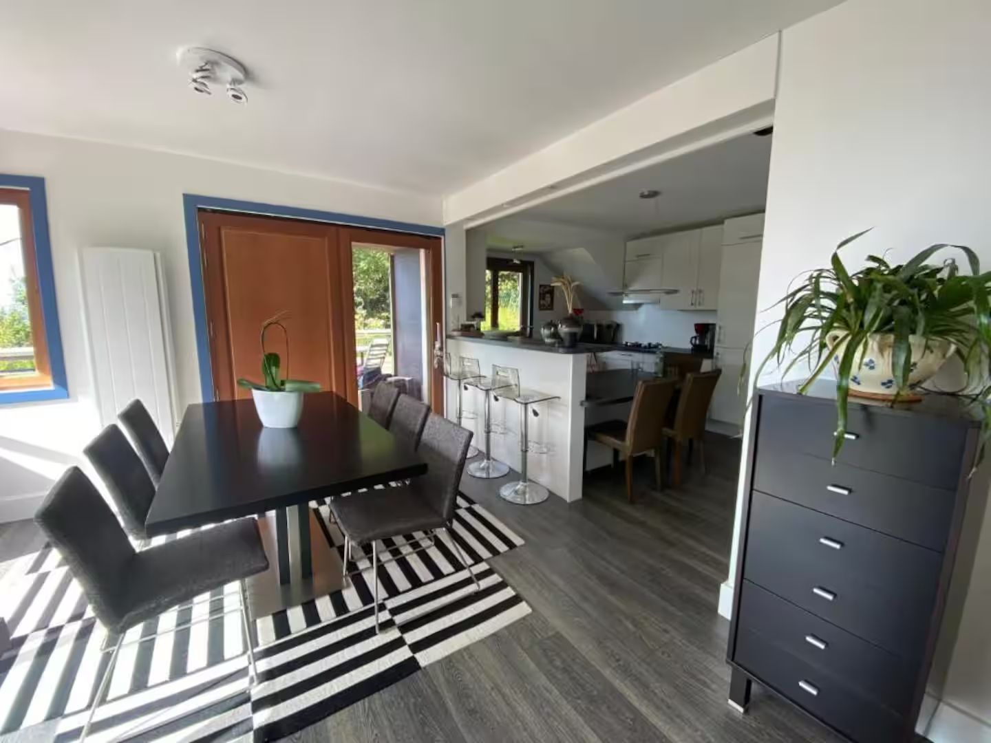 Une salle à manger avec une table et des chaises et un tapis rayé.