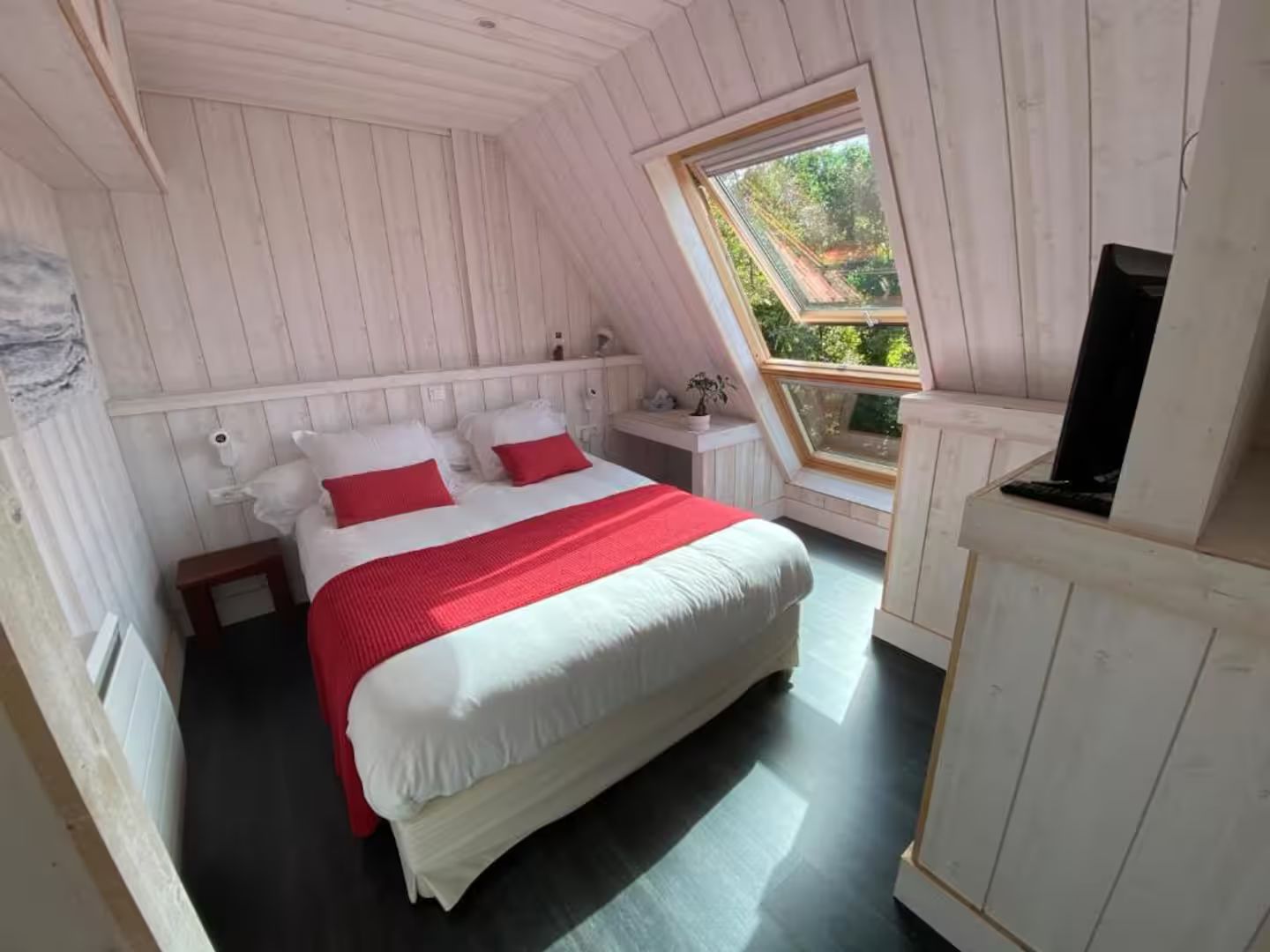 Une chambre avec un grand lit et une fenêtre.