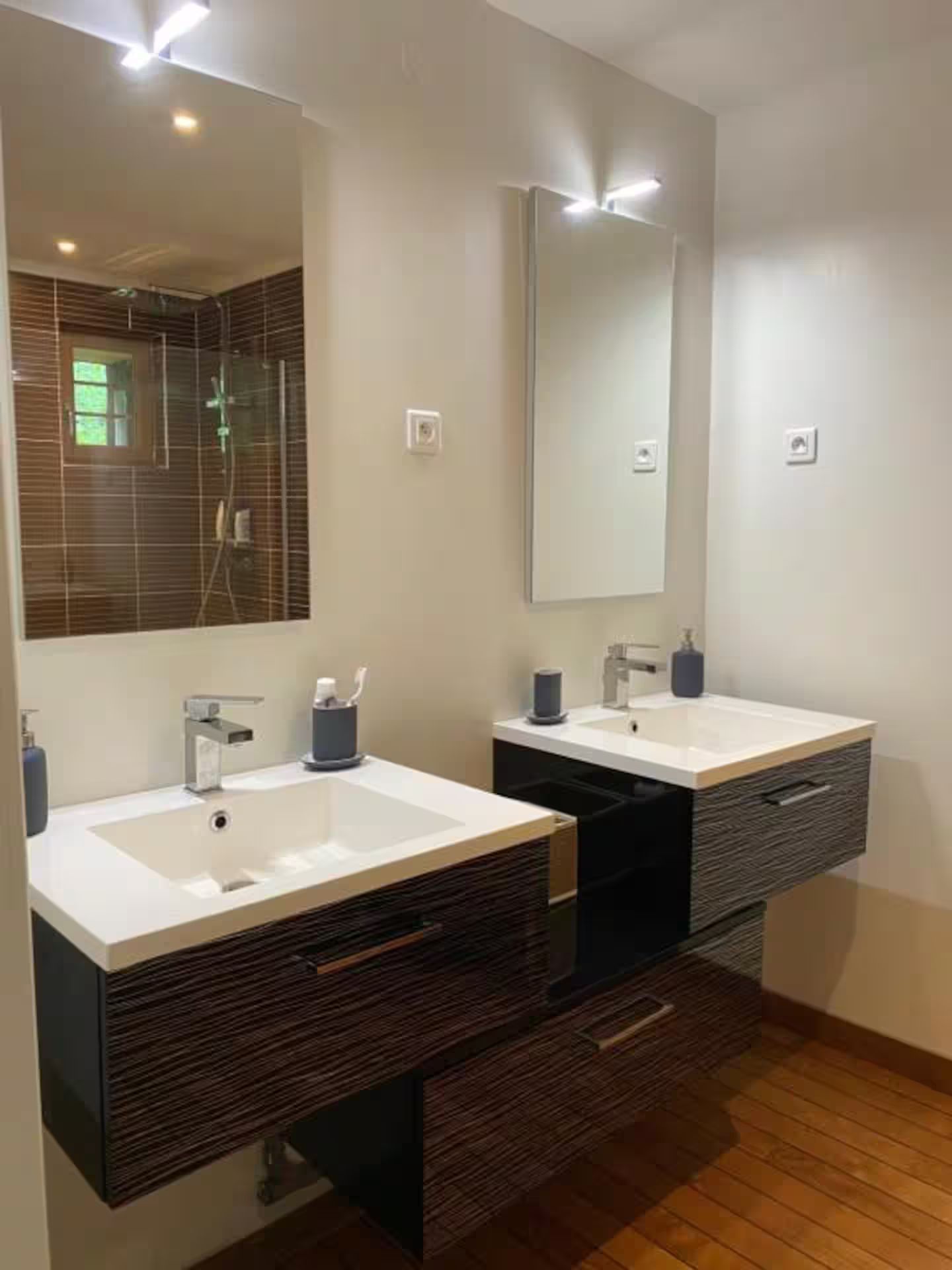 Une salle de bain avec deux lavabos et un miroir.