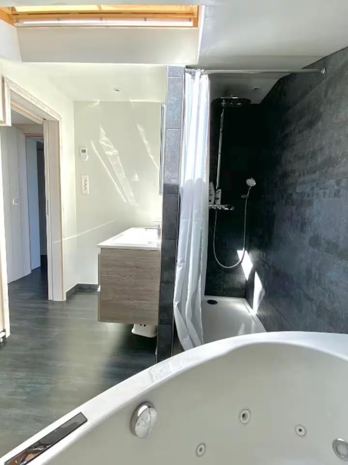 Une salle de bain avec baignoire jacuzzi et douche.