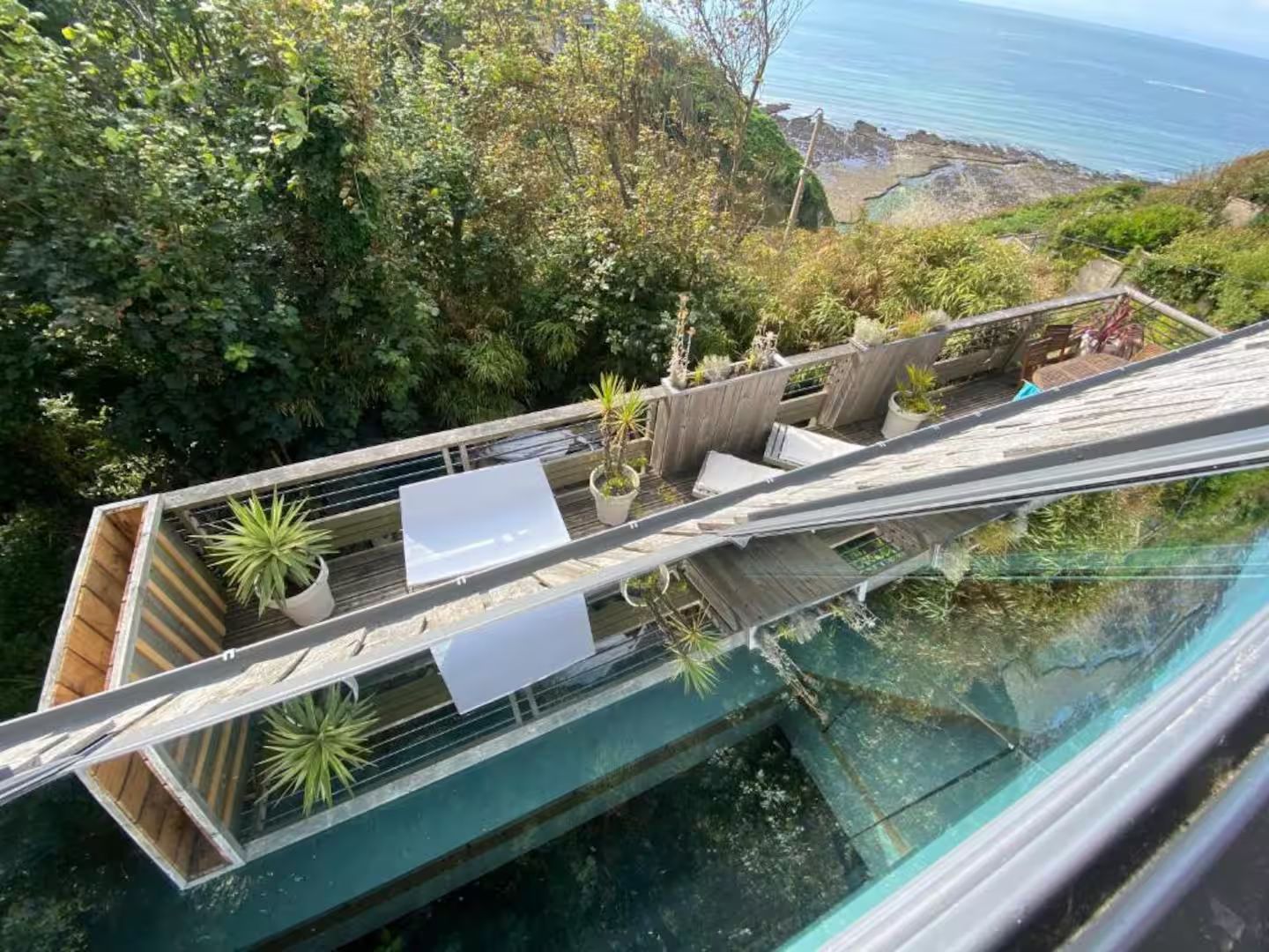 Une vue aérienne d'une maison sur une colline surplombant l'océan.