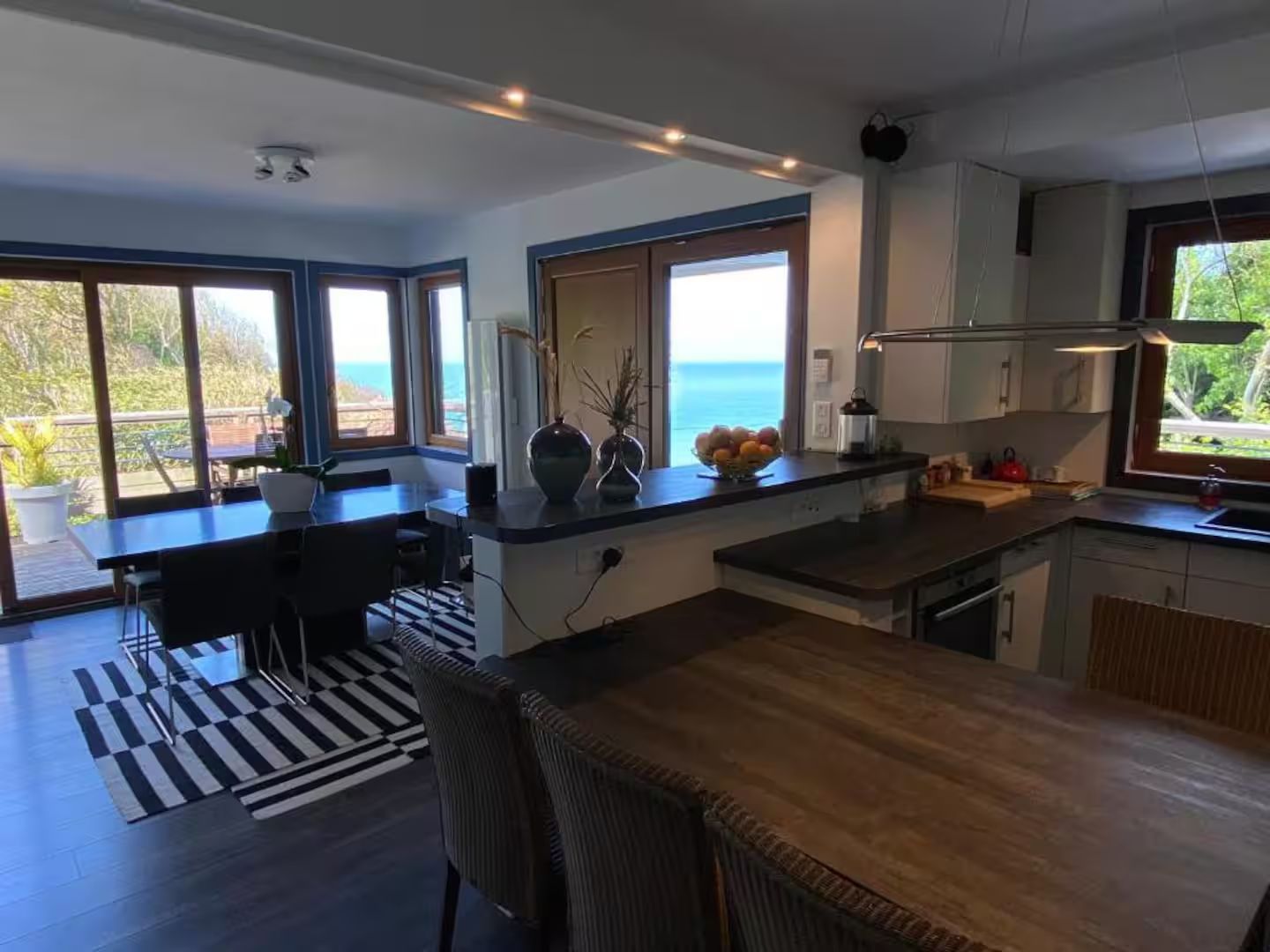 Une cuisine avec une table et des chaises et une vue sur l'océan.