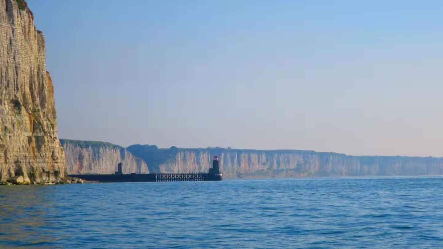 Une grande étendue d'eau avec une falaise en arrière-plan.