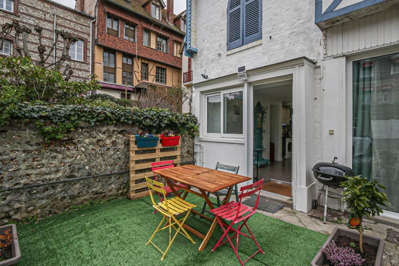 Vue extérieure du gite avec la terrasse une table et des chaises