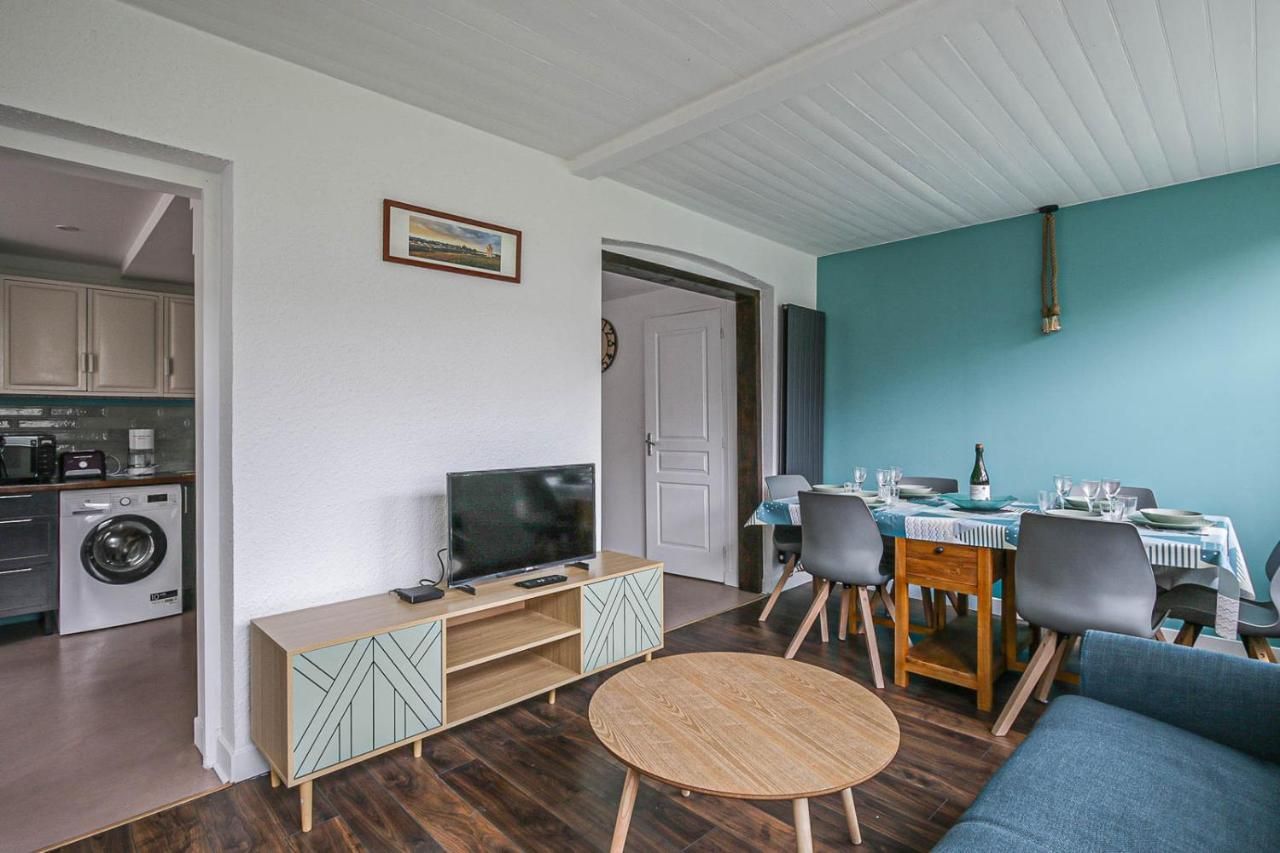 Salon du gite avec lave linge télé canapé et table pour 6 personnes