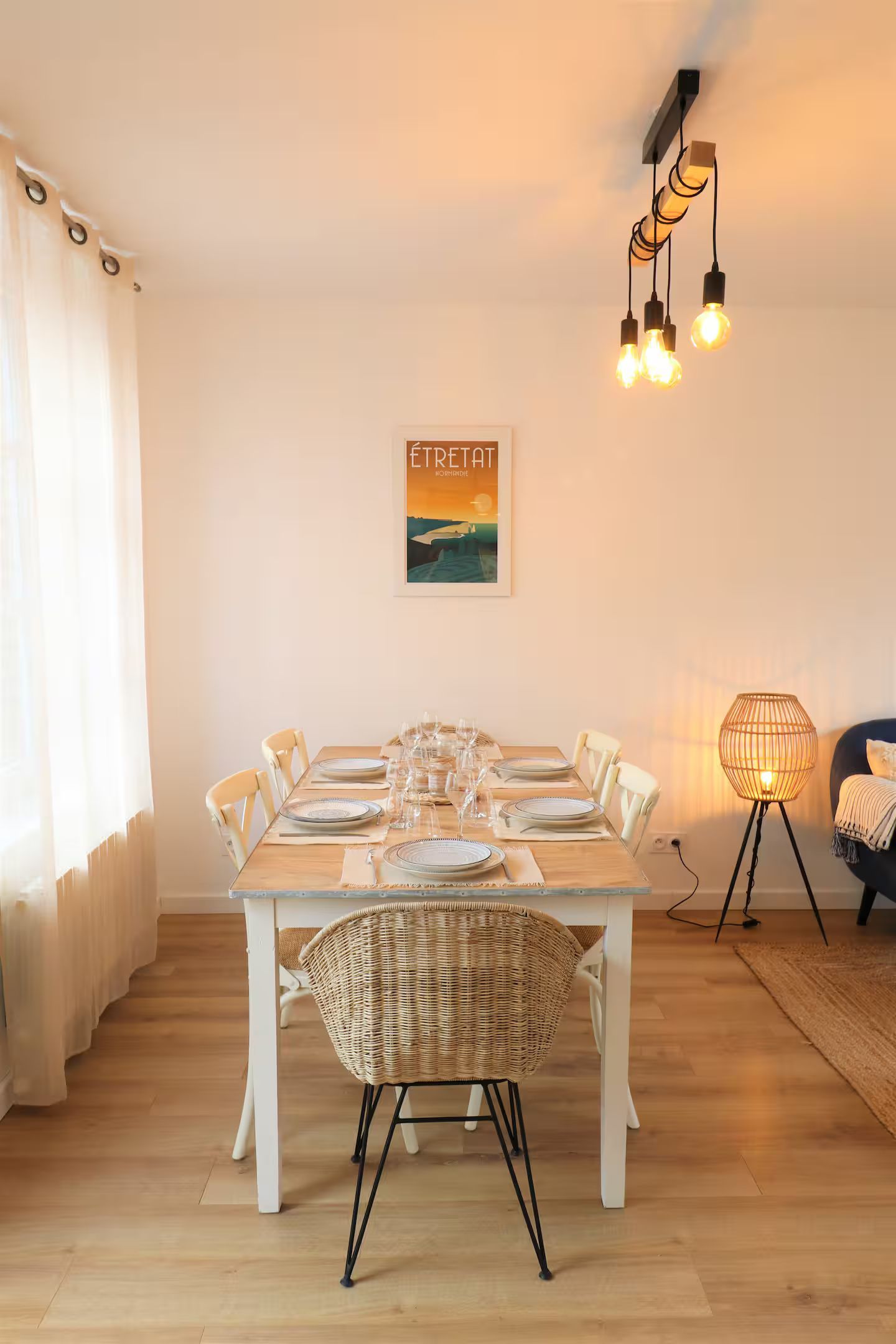 Une salle à manger avec une table et des chaises et un tableau au mur.