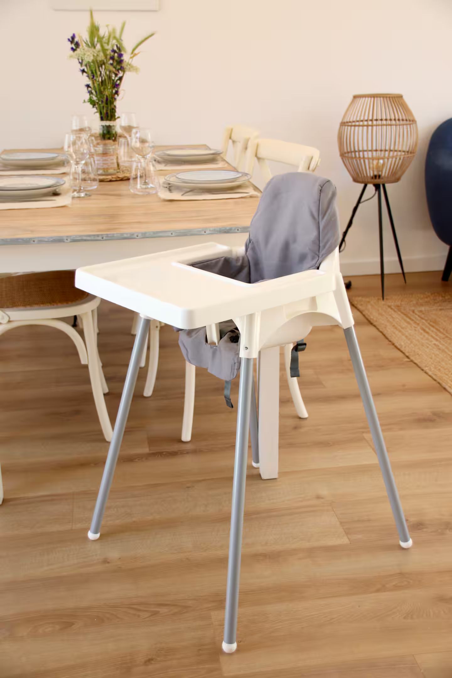 Une chaise haute blanche est posée dans une salle à manger à côté d'une table.