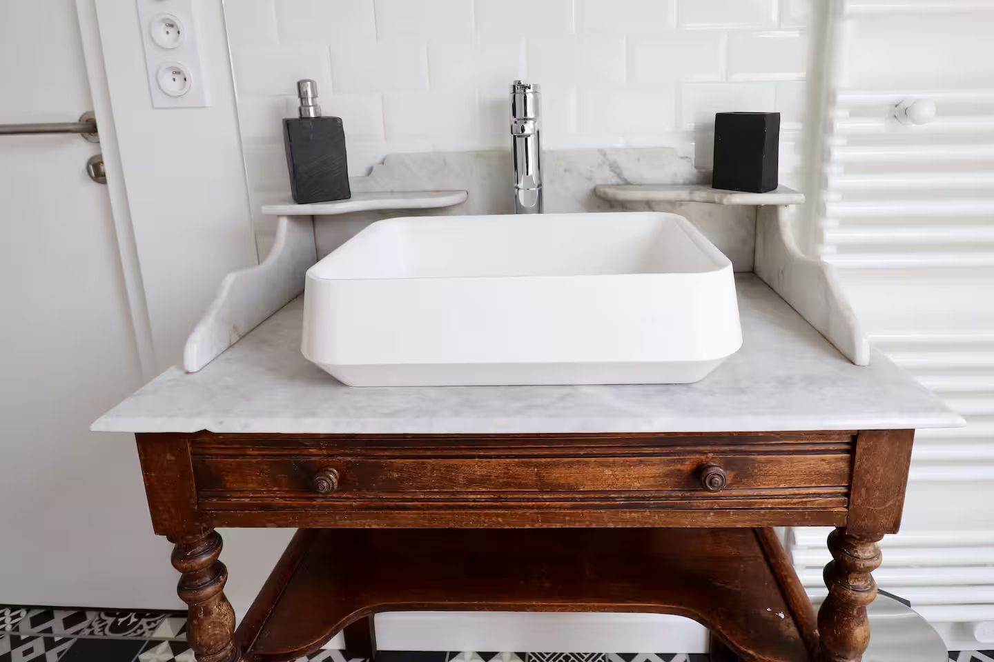 Un lavabo de salle de bain est posé sur une table en bois.