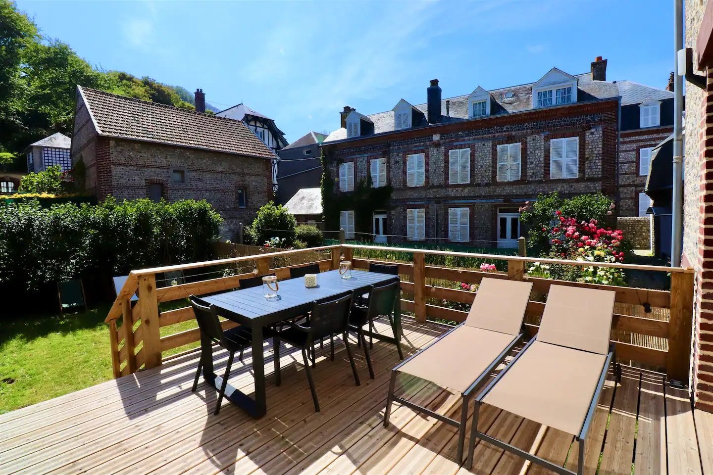 Une terrasse en bois avec une table et des chaises dessus