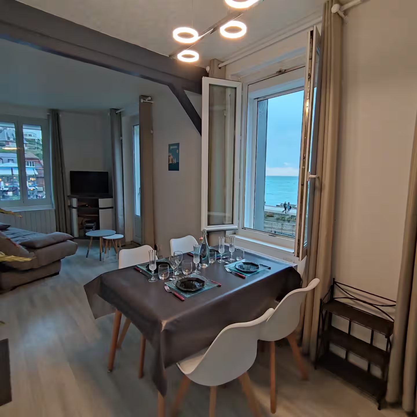 Un salon avec une table et des chaises et une fenêtre