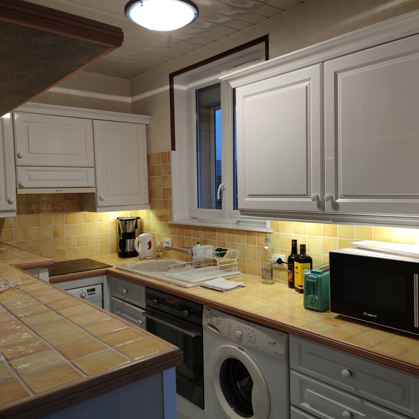 Une cuisine avec un lave-linge et un micro-ondes