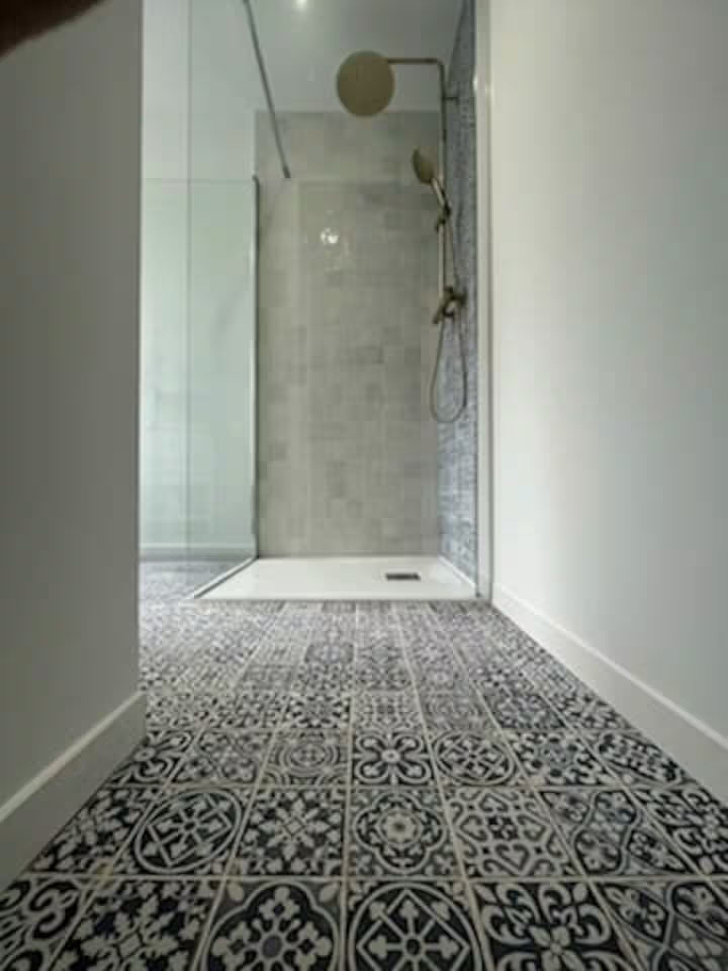 Une salle de bain avec douche à l'italienne et sol carrelé.