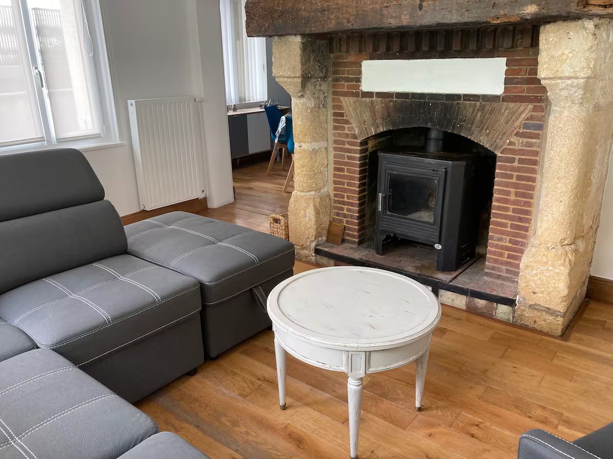 Un salon avec un canapé, une table et une cheminée.