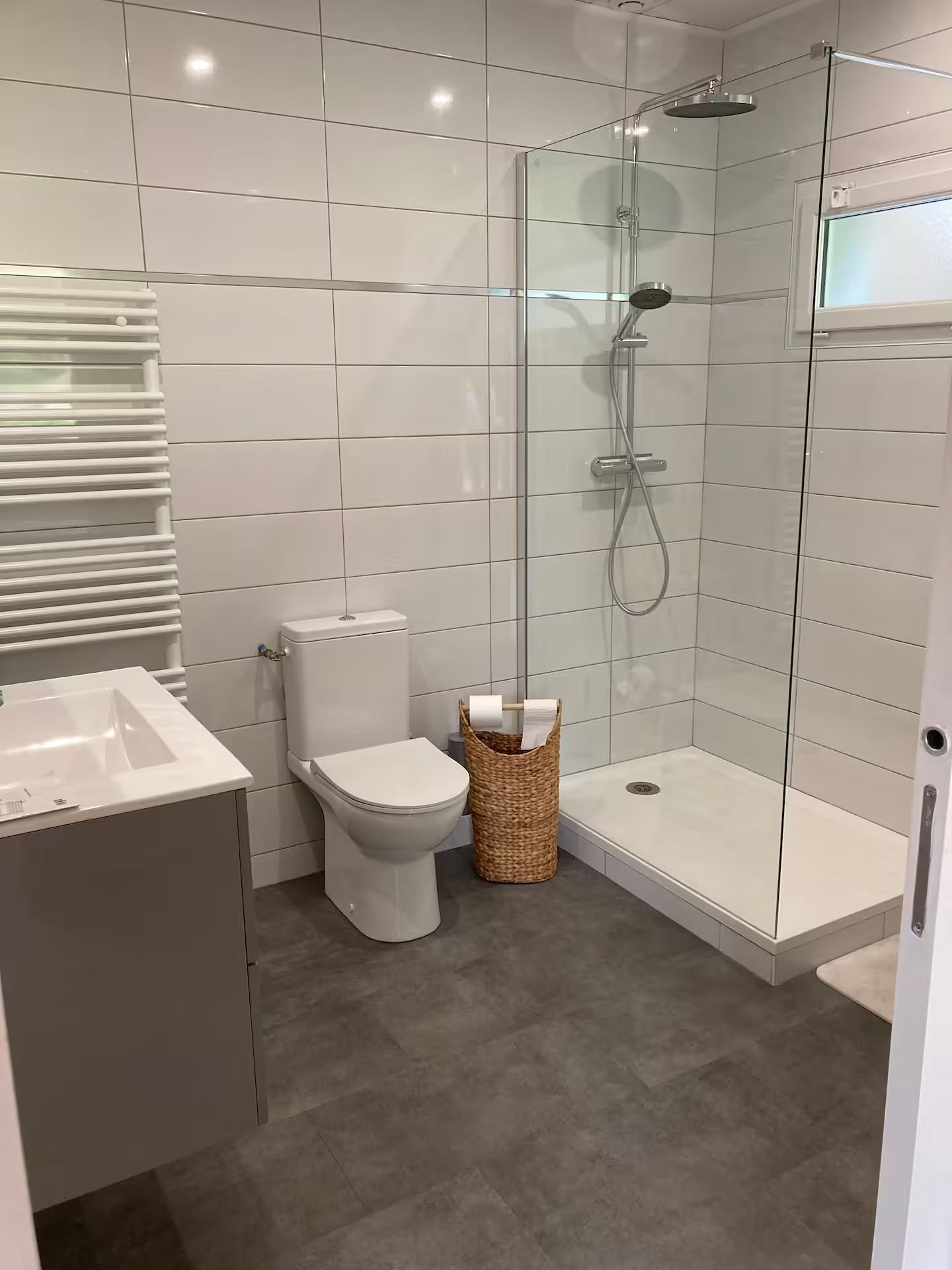 Une salle de bain avec WC, lavabo et douche.