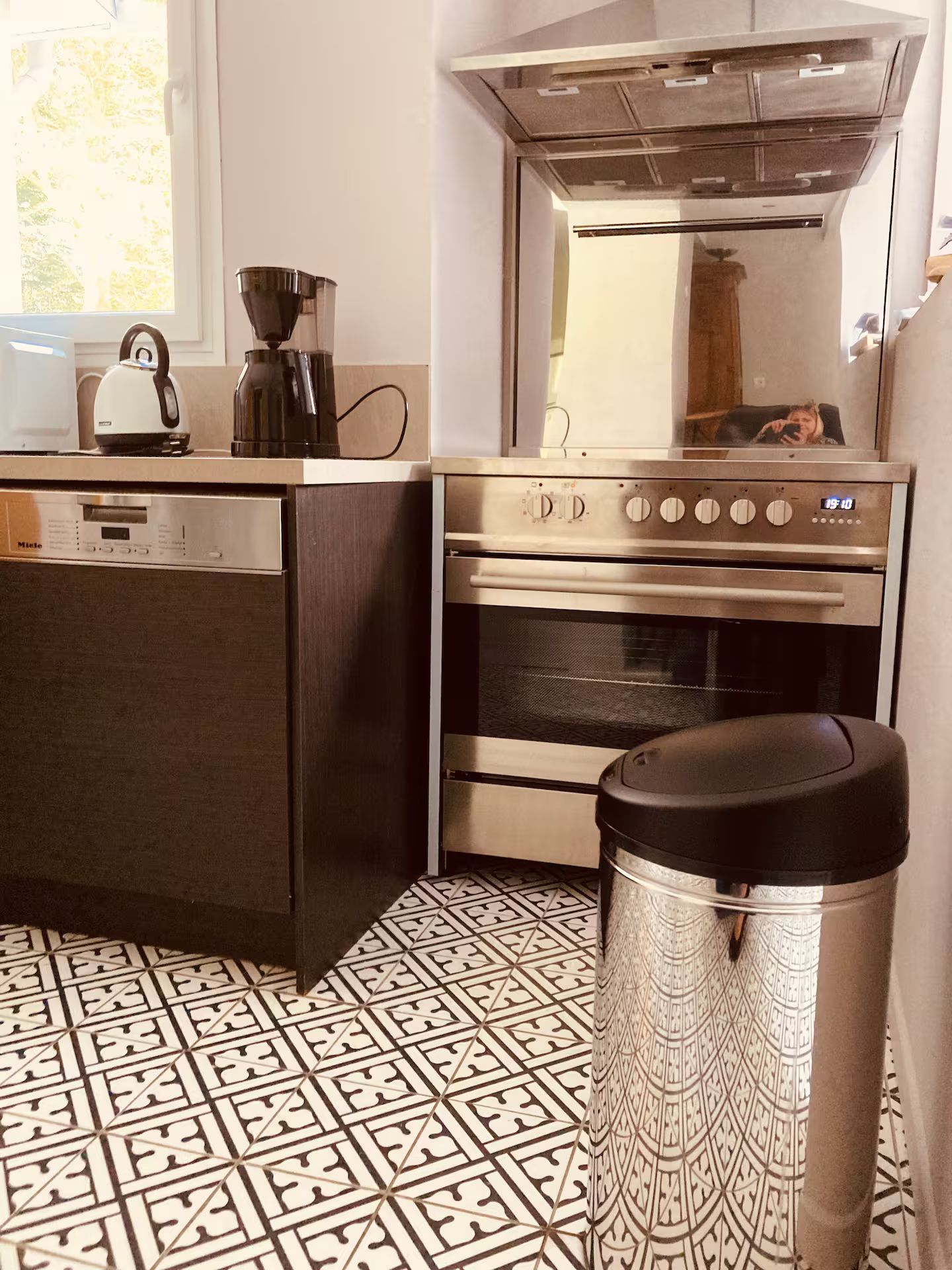 Une cuisine avec une cuisinière et une poubelle