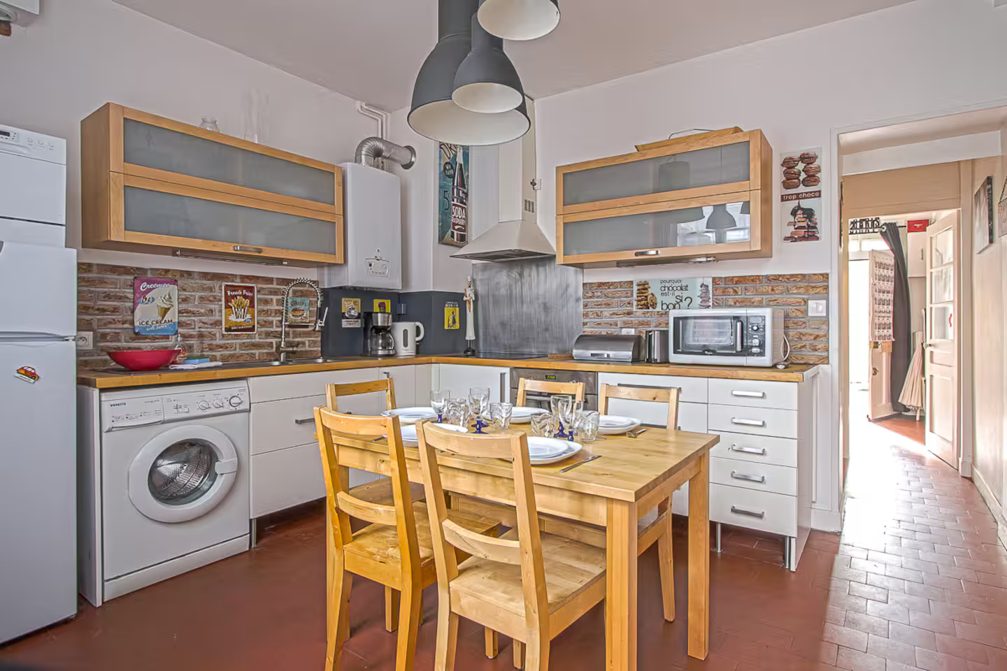 Une cuisine avec une table et des chaises et un réfrigérateur.