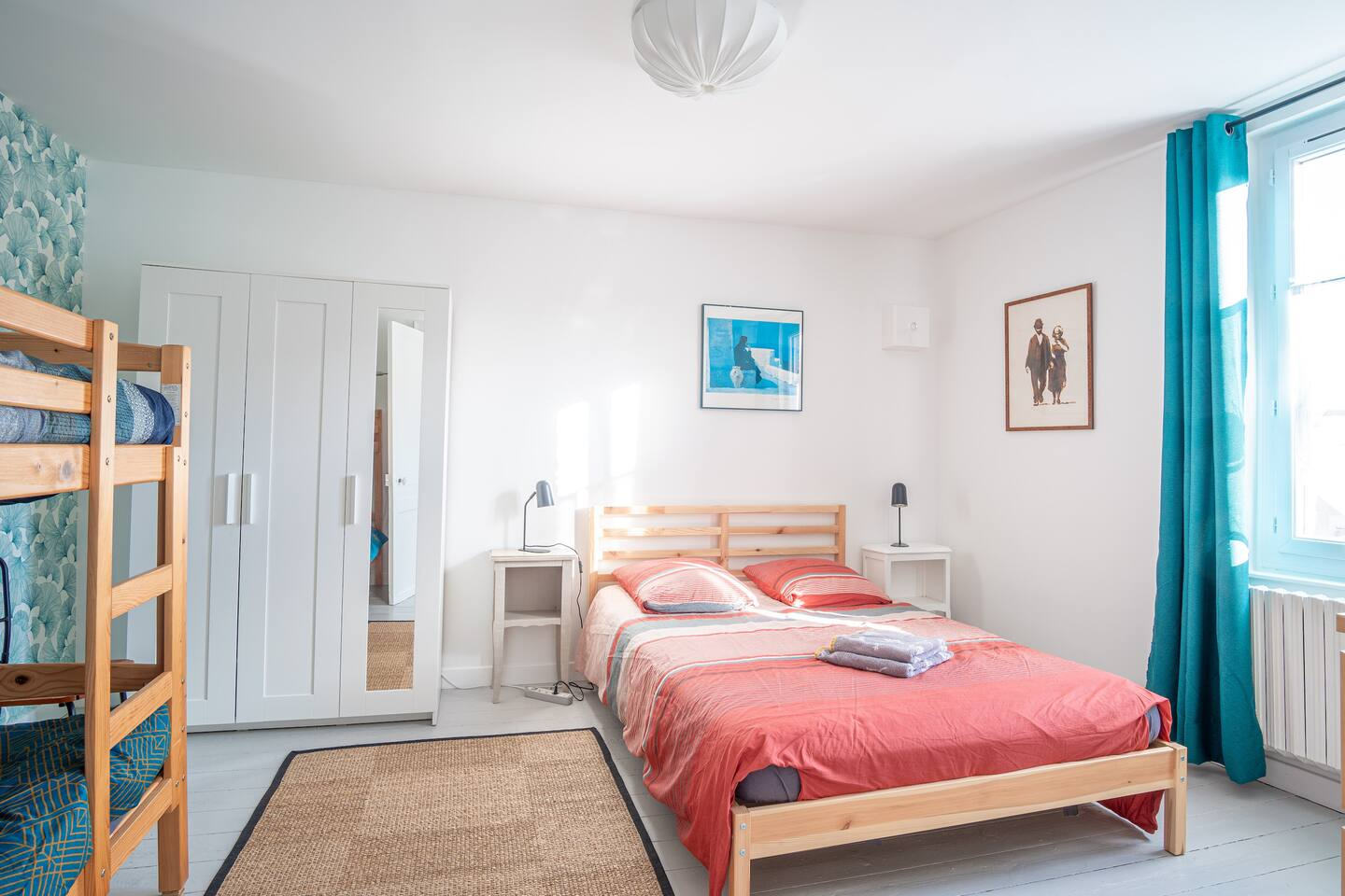 Une chambre avec un grand lit et des lits superposés.