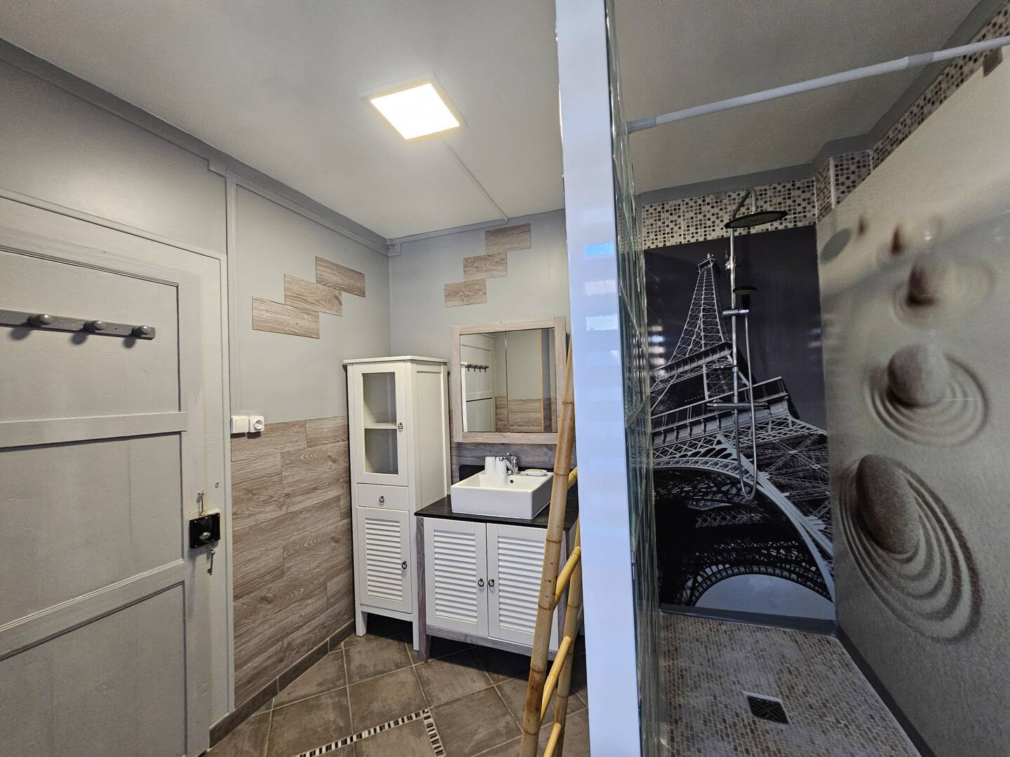 Il y a une photo de la tour Eiffel sur le mur de la salle de bain.