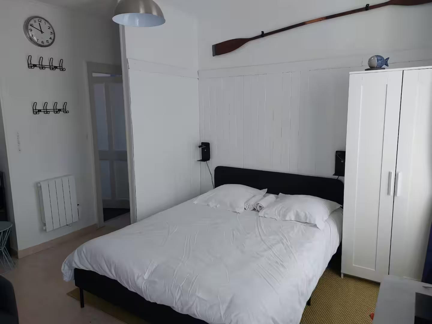 Une chambre avec un lit et une horloge au mur