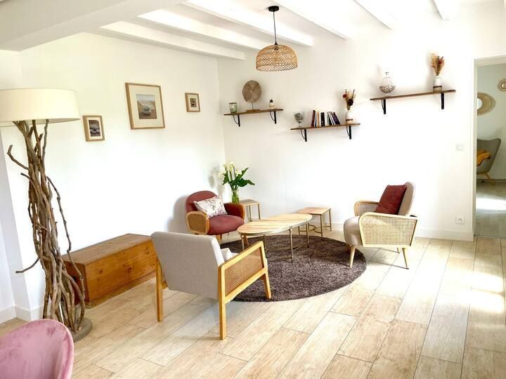 Salon avec murs couleur crème, meubles en bois et petit coin salon.